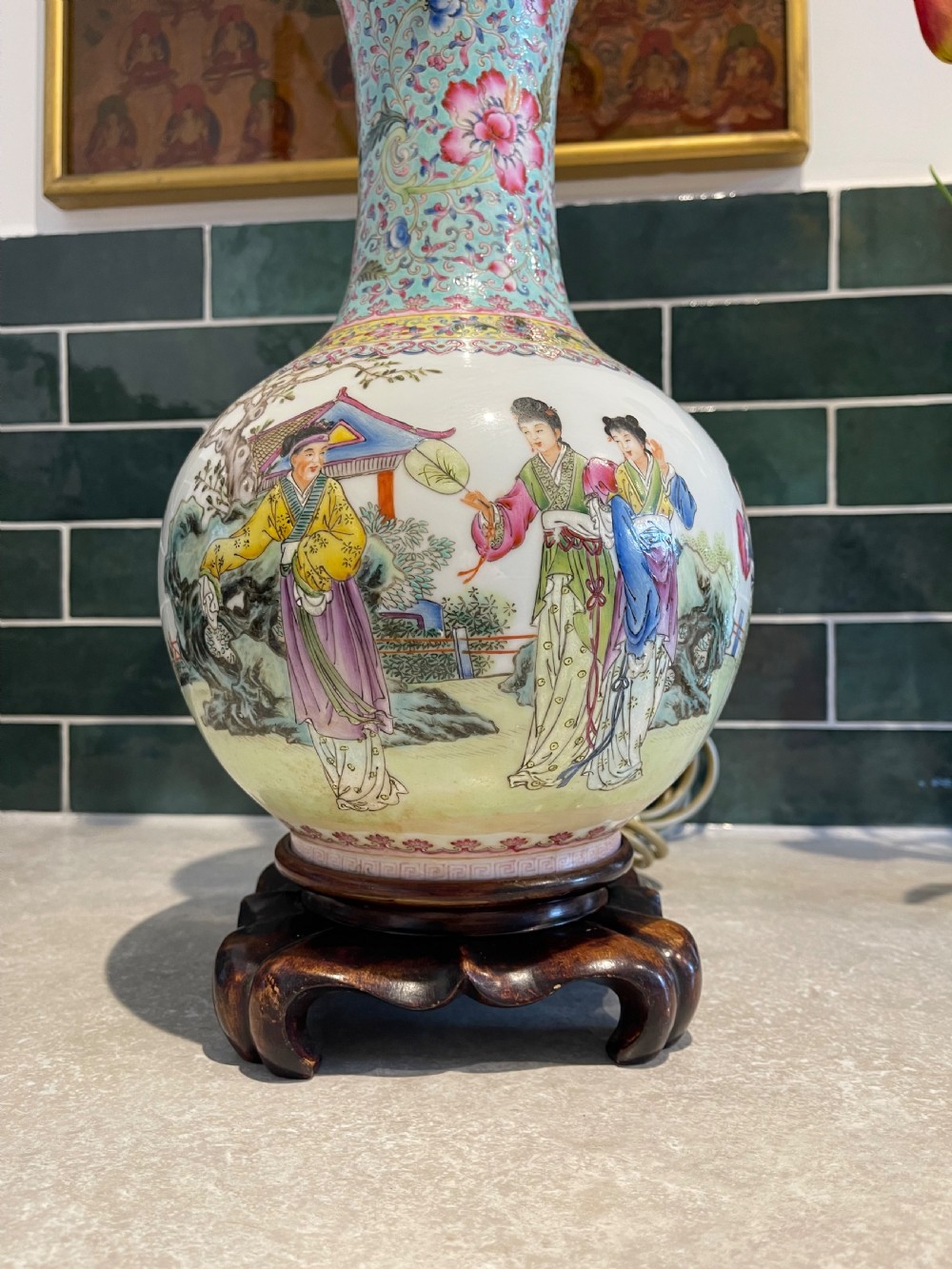 A Chinese Famille Rose porcelain vase mounted as a table lamp with hand-painted figures, floral motifs, brass double sockets, and a carved wooden base. View VI