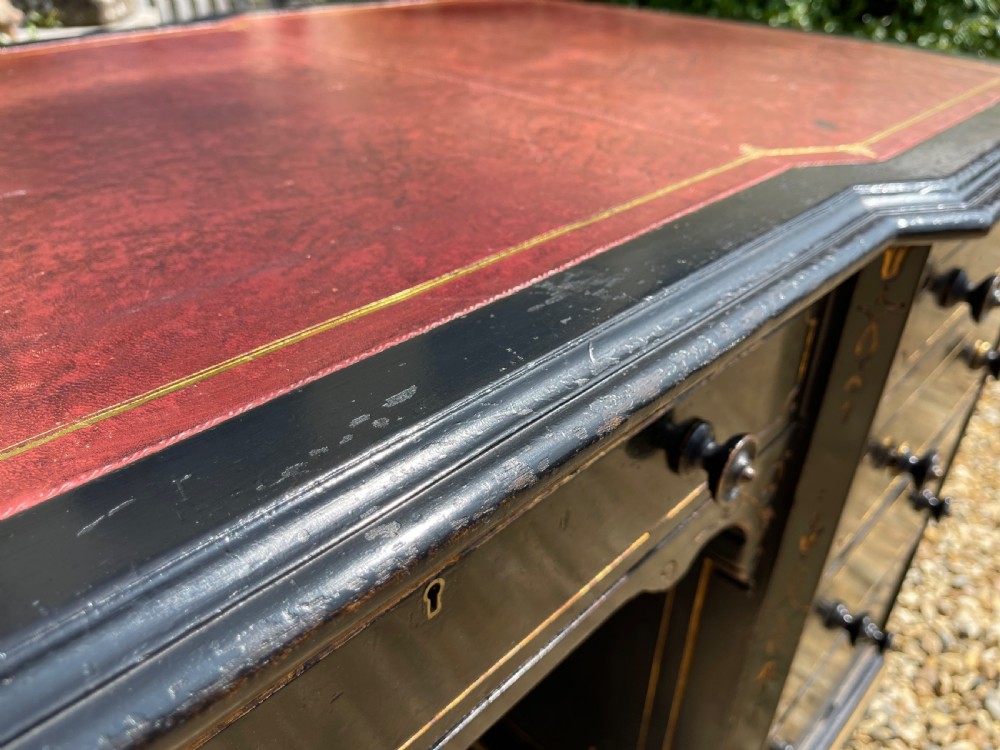 A nineteenth-century ebonised pedestal desk featuring fine gilt line decoration, turned drawer handles, and twin pedestals flanking a central kneehole. View IX