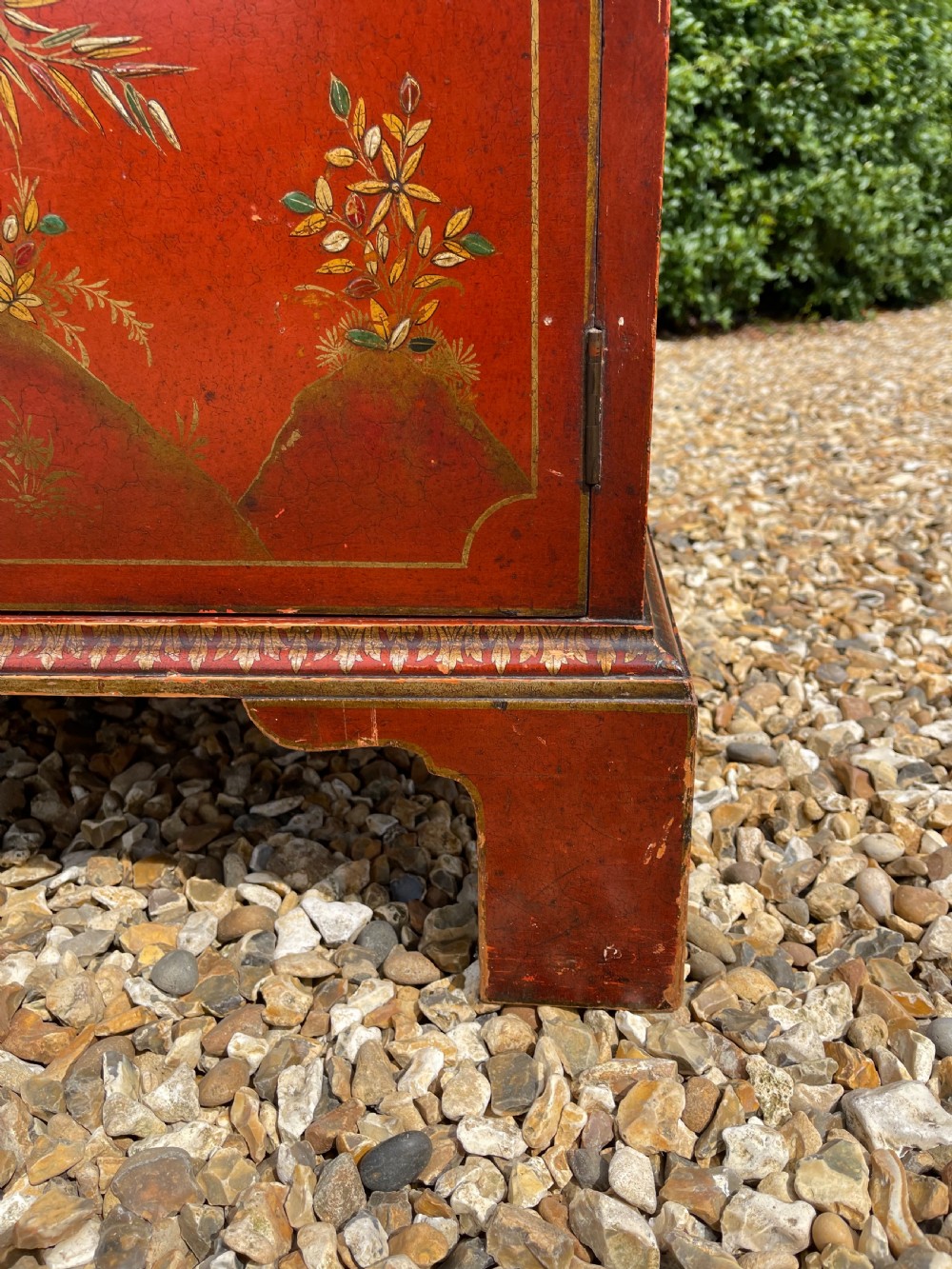 An antique red lacquered fall-front bureau with hand-painted Chinoiserie scenes and a yellow fitted interior featuring cubbies and small drawers. View V