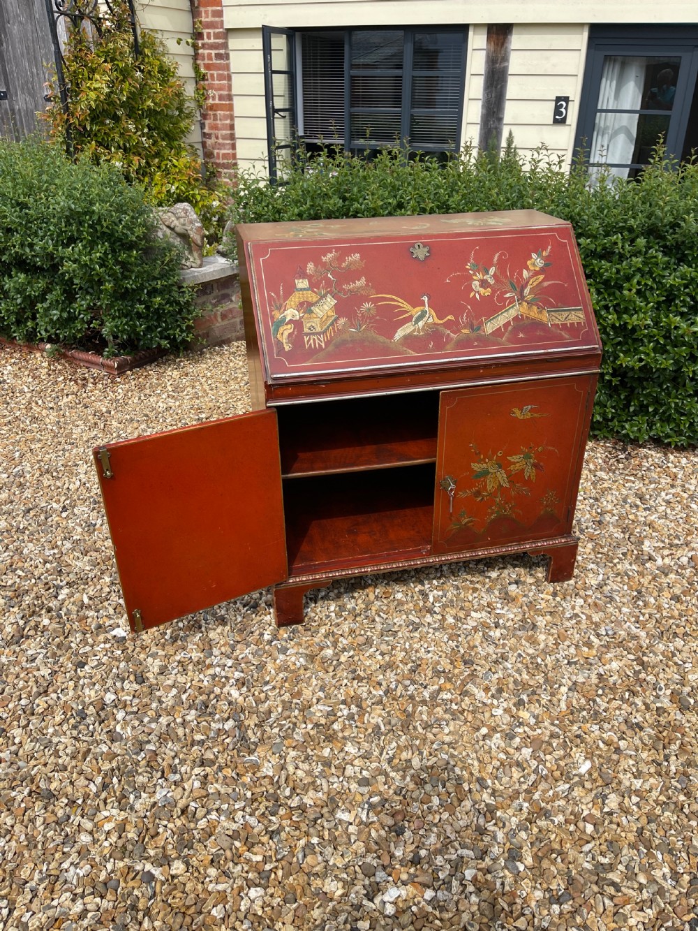 An antique red lacquered fall-front bureau with hand-painted Chinoiserie scenes and a yellow fitted interior featuring cubbies and small drawers. View XII