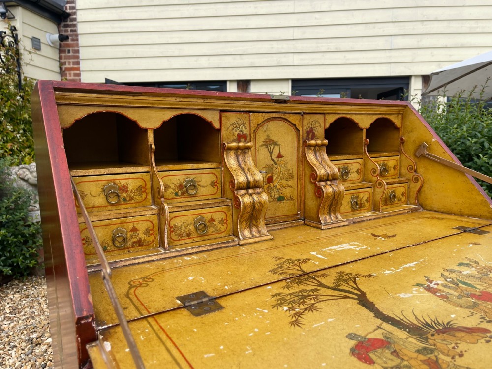 An antique red lacquered fall-front bureau with hand-painted Chinoiserie scenes and a yellow fitted interior featuring cubbies and small drawers. View XIV