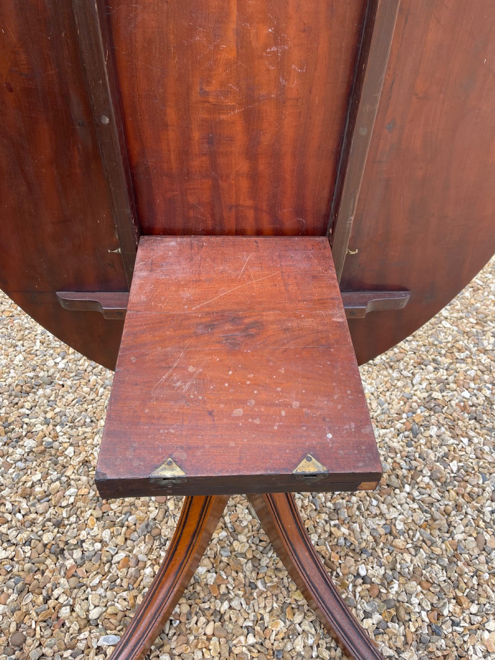 An oval George III mahogany breakfast table with crossbanded satinwood border on a central pedestal base with four splayed legs terminating in brass castors. View IX