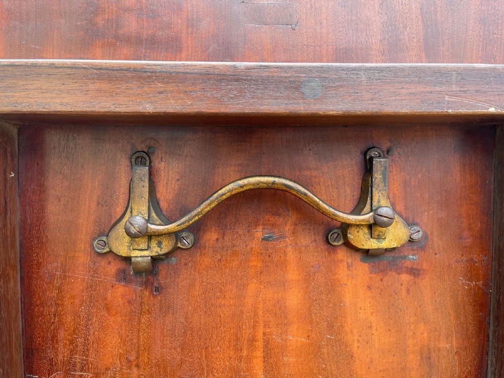 An oval George III mahogany breakfast table with crossbanded satinwood border on a central pedestal base with four splayed legs terminating in brass castors. View X