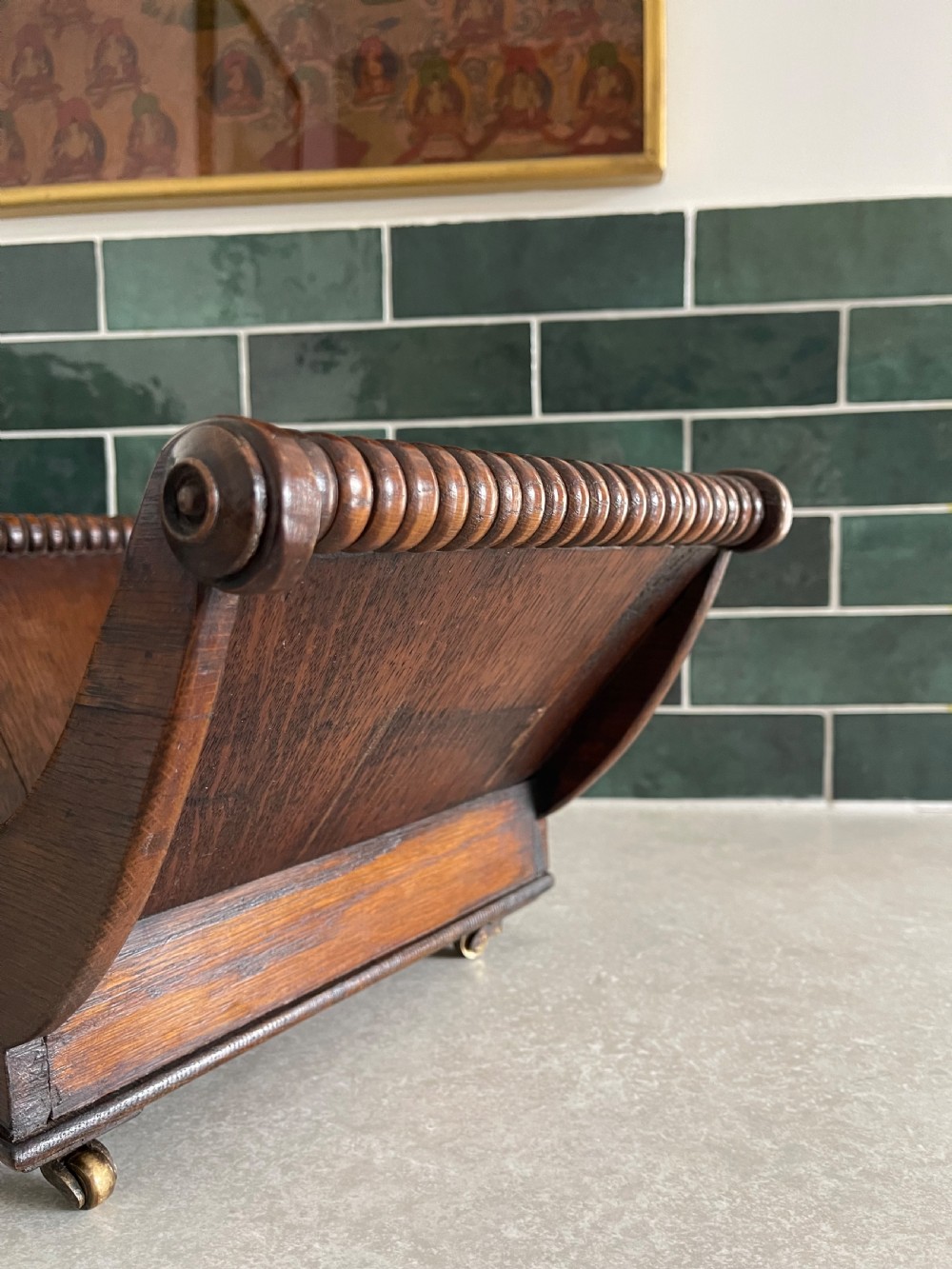 A dark oak Georgian cheese coaster with crescent-shaped sides, turned gadrooned rails, and small brass castors on the base. View VI
