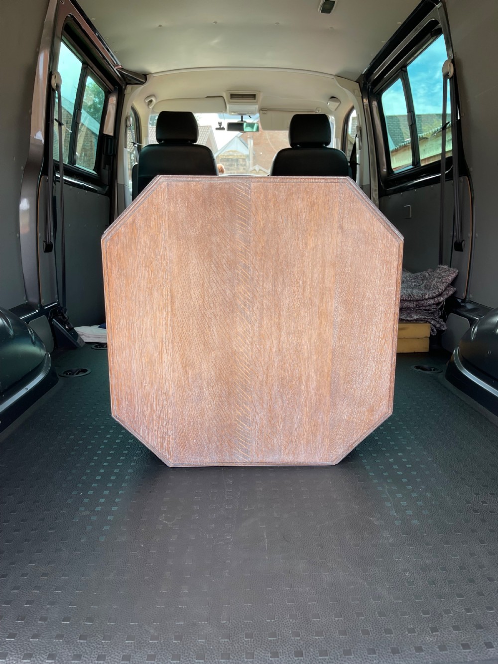 A 1930s Heals style limed oak book table featuring an octagonal top, lower open shelf, and angled slab legs with a chalky grain finish. View III