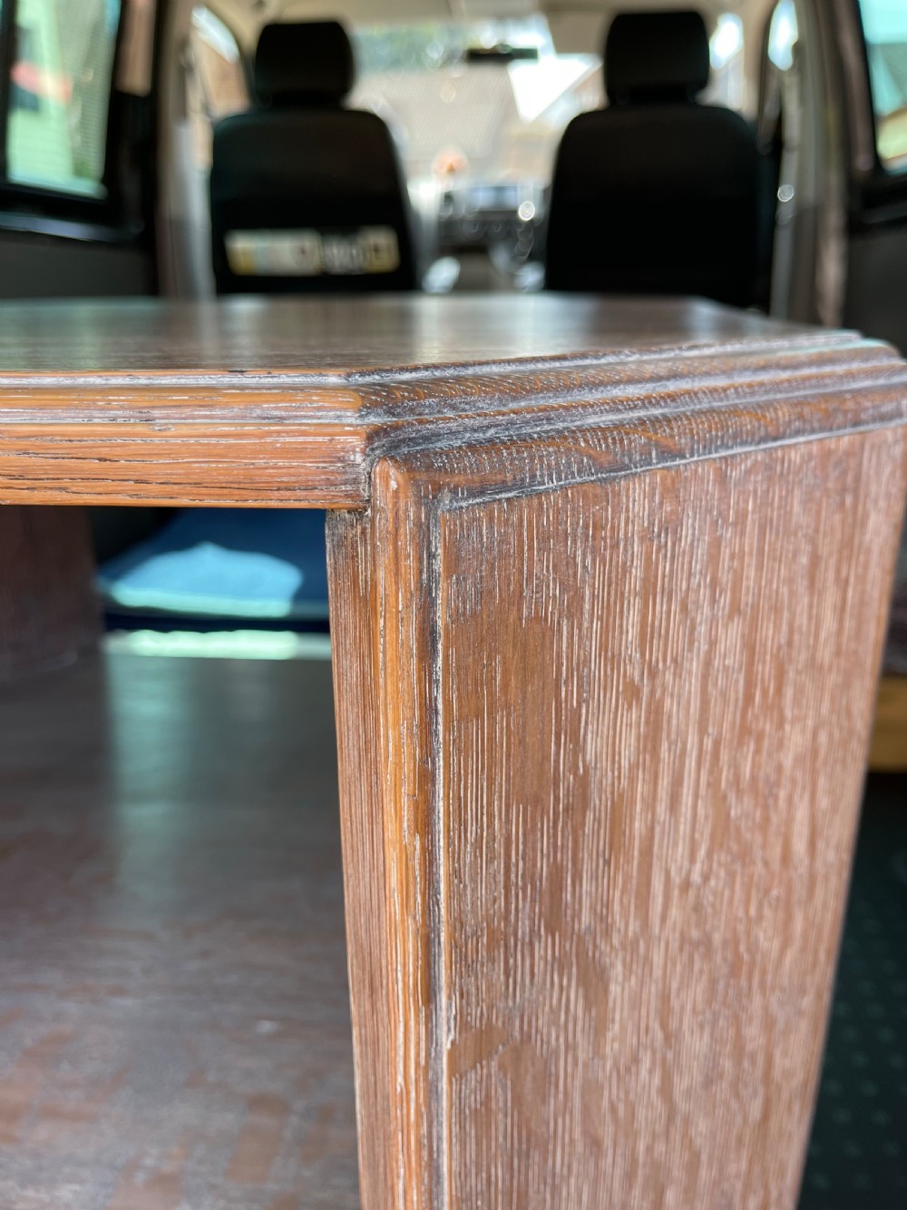 A 1930s Heals style limed oak book table featuring an octagonal top, lower open shelf, and angled slab legs with a chalky grain finish. View VII