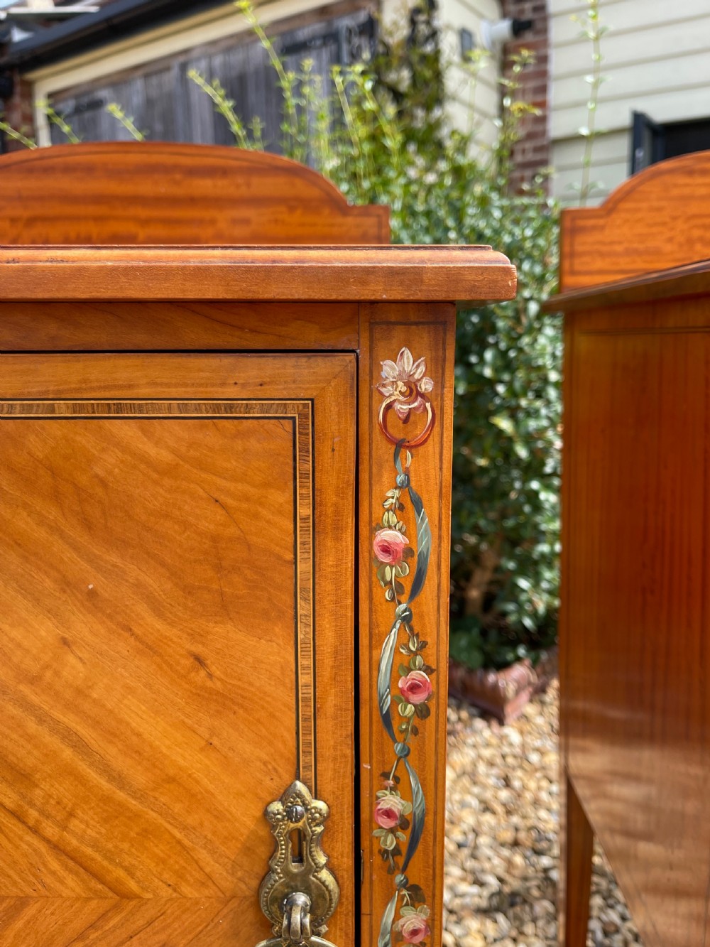 A pair of Edwardian satinwood bedside cupboards featuring diamond marquetry door panels, hand-painted floral stiles, and square tapered legs. View II