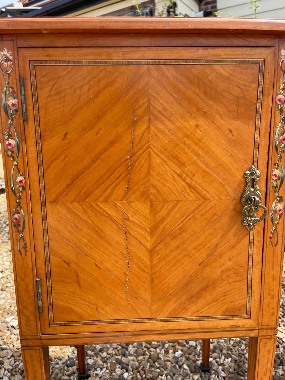 A pair of Edwardian satinwood bedside cupboards featuring diamond marquetry door panels, hand-painted floral stiles, and square tapered legs. View III