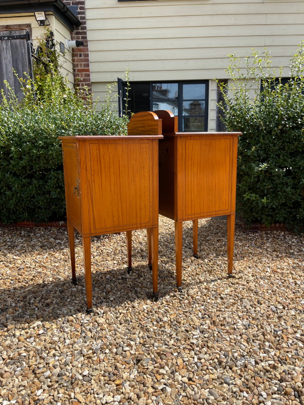 A pair of Edwardian satinwood bedside cupboards featuring diamond marquetry door panels, hand-painted floral stiles, and square tapered legs. View VI