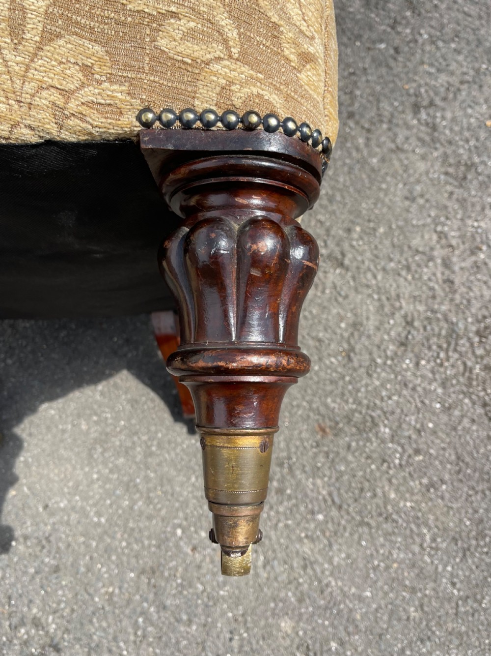 A nineteenth-century spoon back armchair upholstered in gold patterned damask fabric with turned dark timber front legs on brass castors. View VII