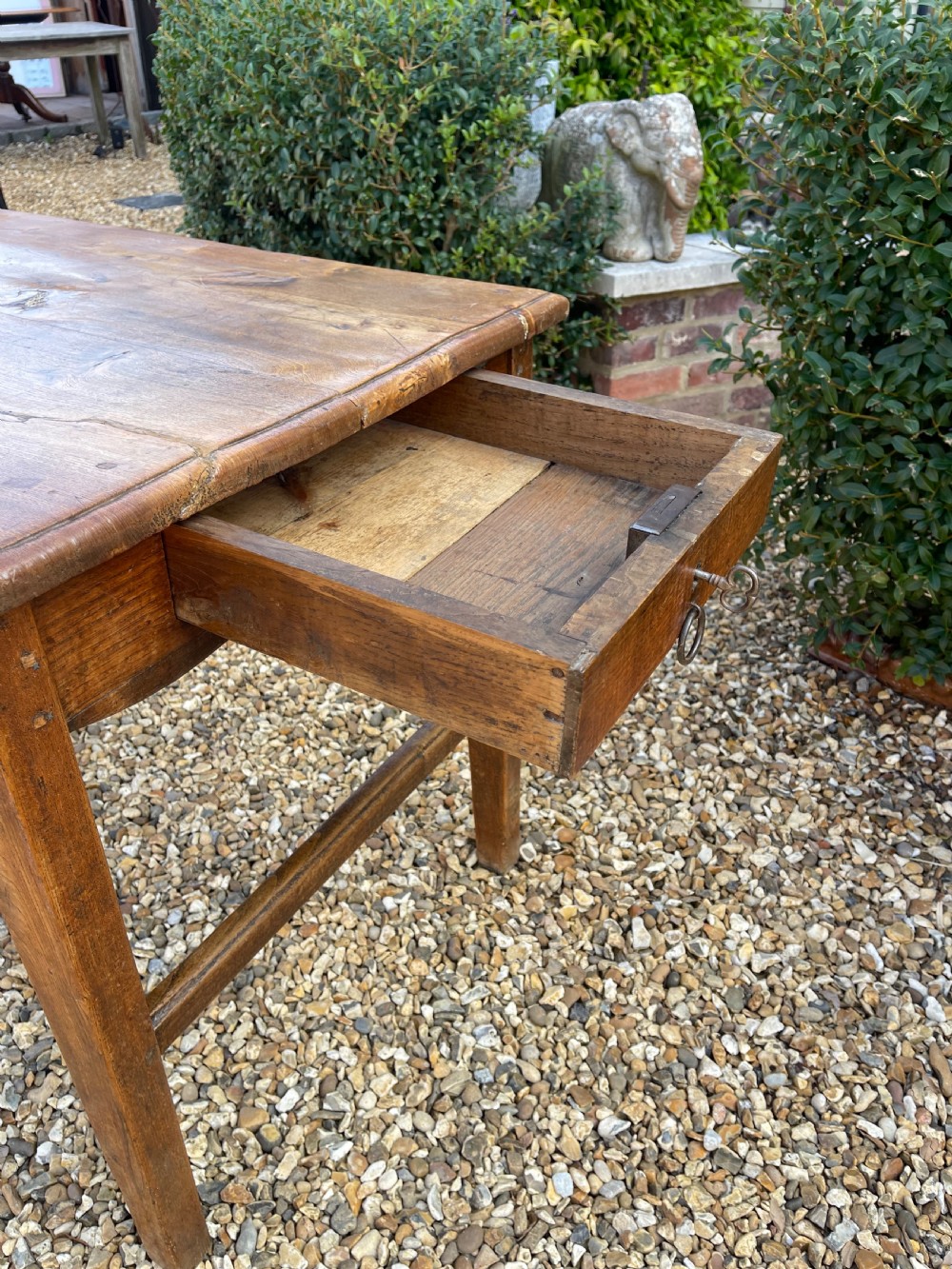 A long antique elm refectory table featuring a natural wood grain finish, straight legs, and end stretchers. View VIII