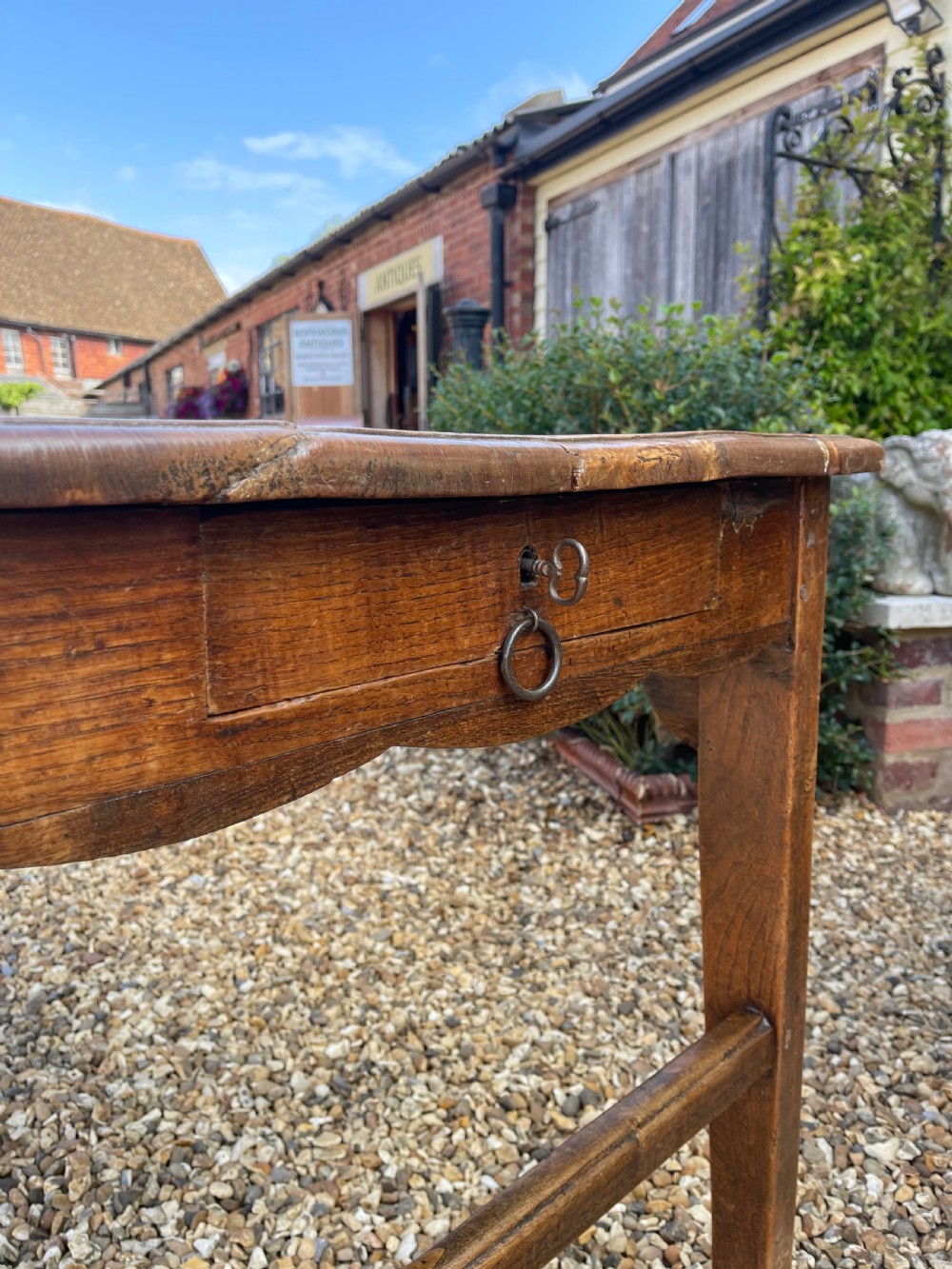 A long antique elm refectory table featuring a natural wood grain finish, straight legs, and end stretchers. View IX