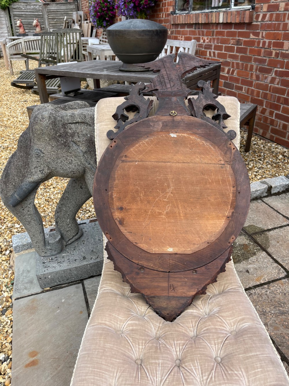A carved dark timber convex wall mirror featuring a crested eagle surmount, spherical frame embellishments, and a circular convex glass plate. View VI