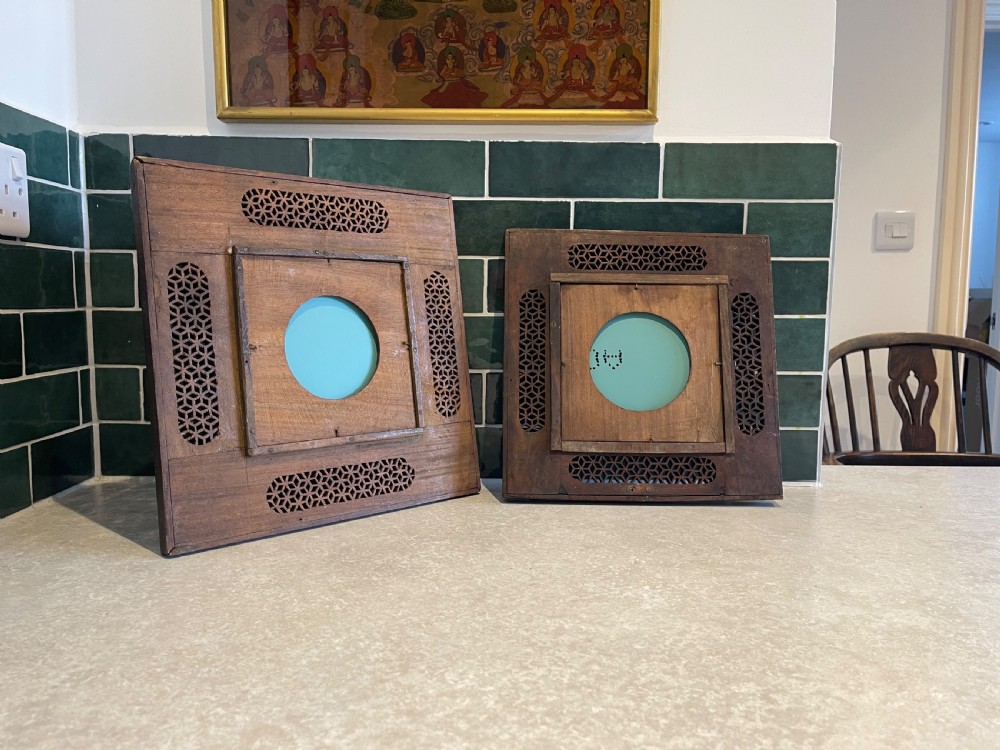 A pair of square dark wood framed mirrors featuring intricate floral brass inlay and pierced geometric jaali lattice panels. View II
