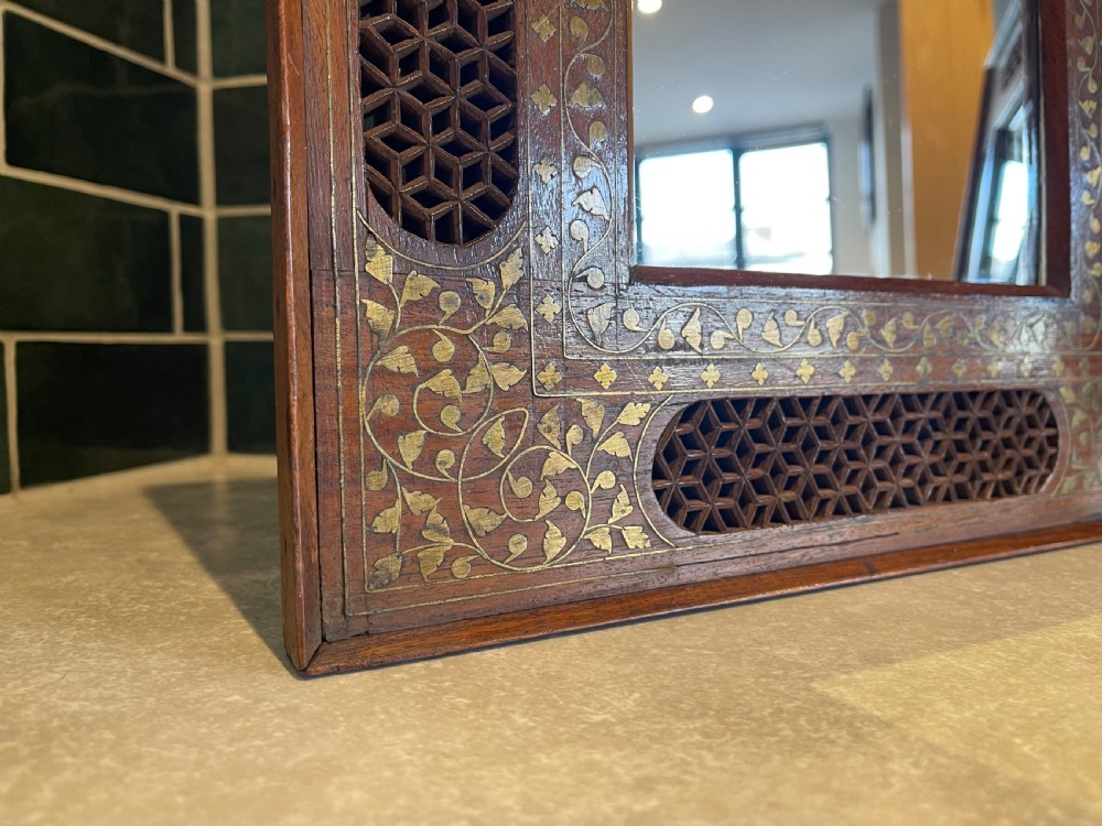 A pair of square dark wood framed mirrors featuring intricate floral brass inlay and pierced geometric jaali lattice panels. View IV