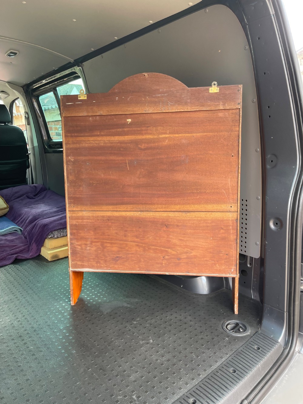 An antique satinwood hanging shelf unit featuring an arched cresting rail, three open tiers, and two drawers at the base with brass drop ring handles. View V