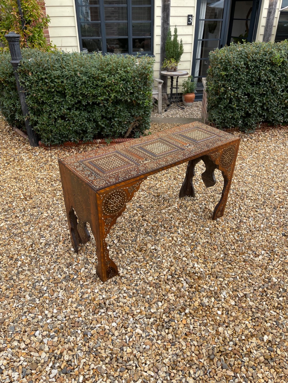 An elongated rectangular walnut console table with intricate geometric bone inlay across the top, apron, and side supports.