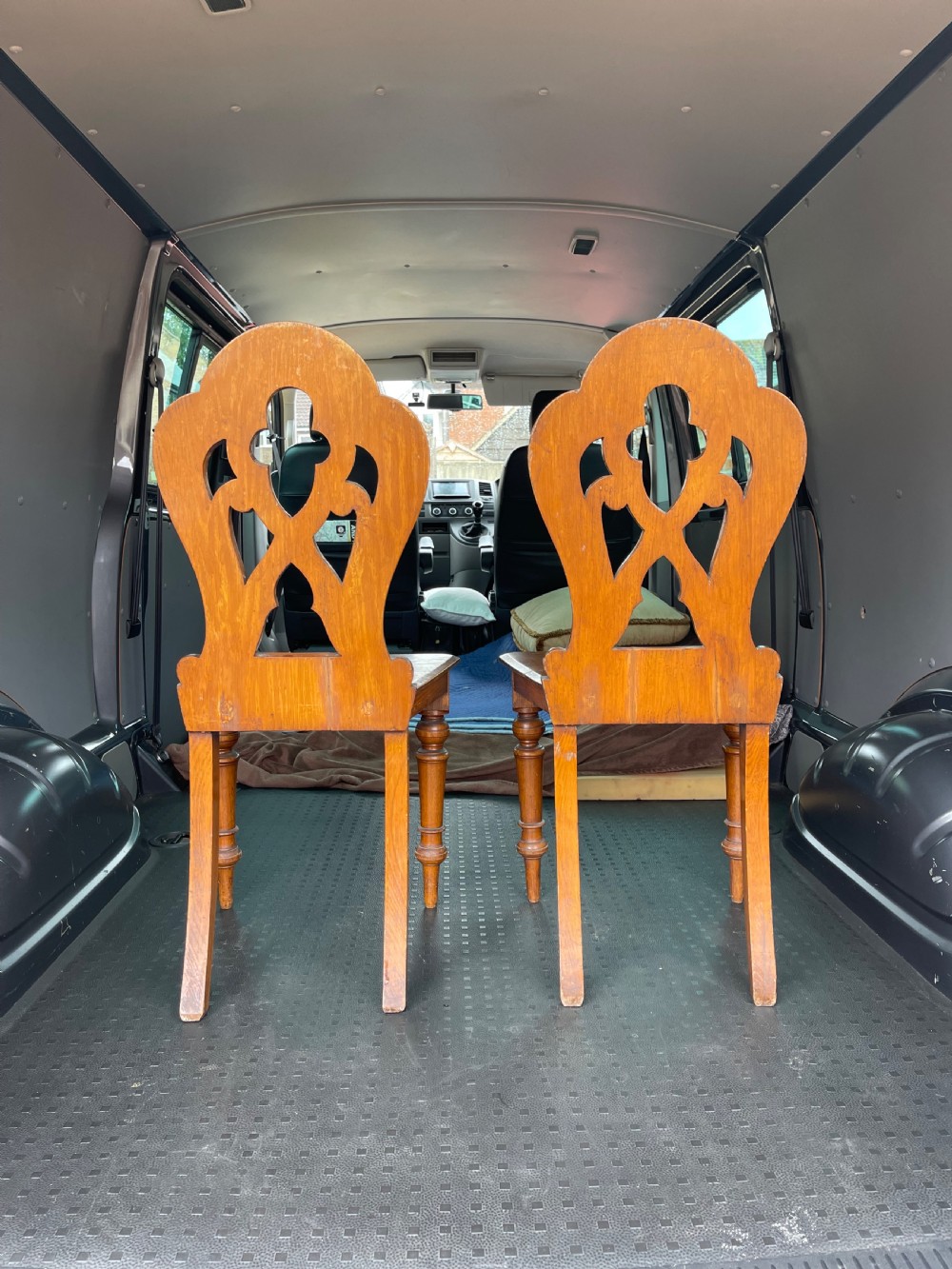 A pair of 19th-century oak hall chairs featuring carved pierced backrests, flat solid wooden seats, and turned front legs. View III