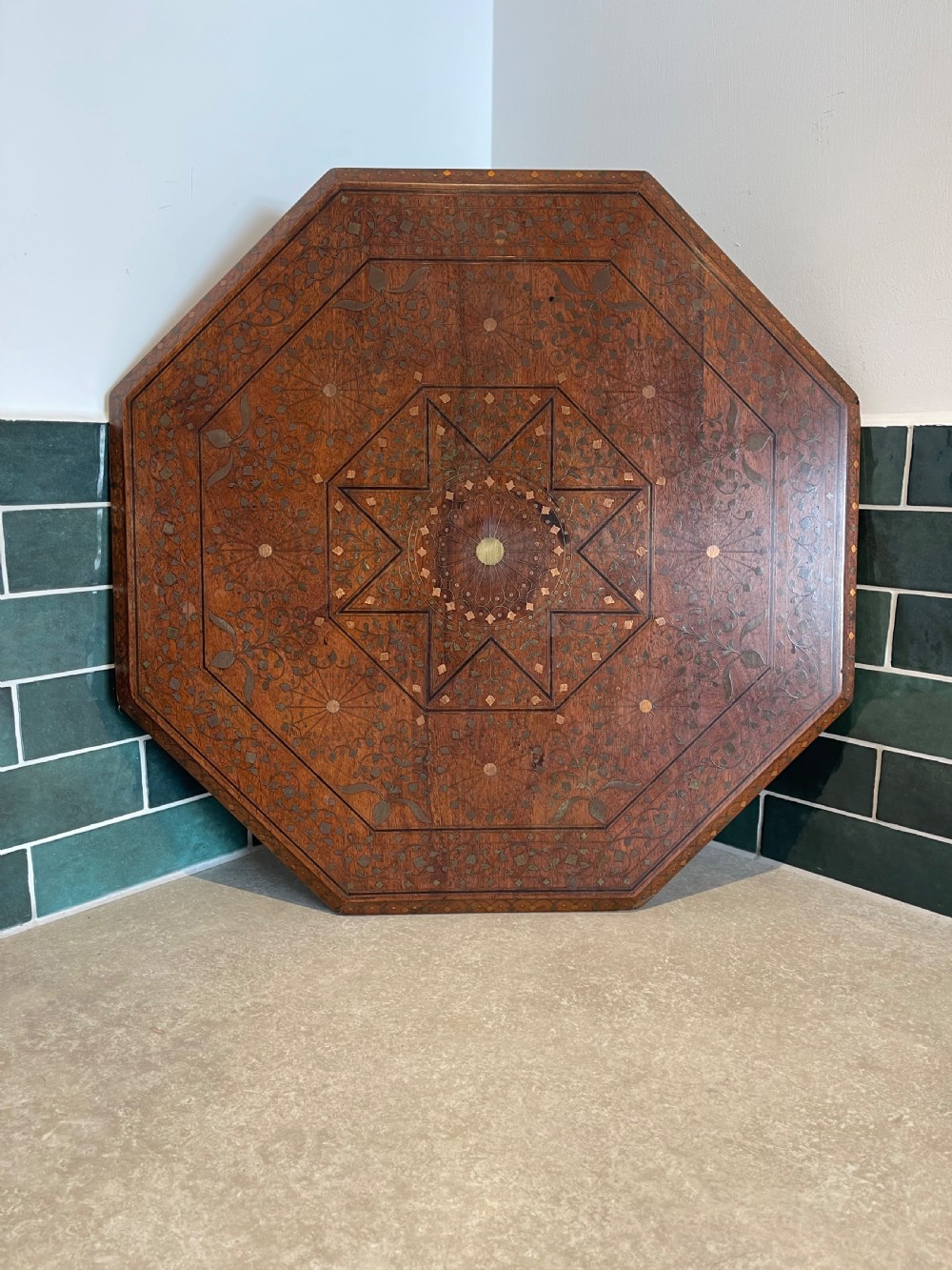 An octagonal Anglo-Indian side table featuring intricate geometric brass inlay on top and carved jali lattice apron panels. View II