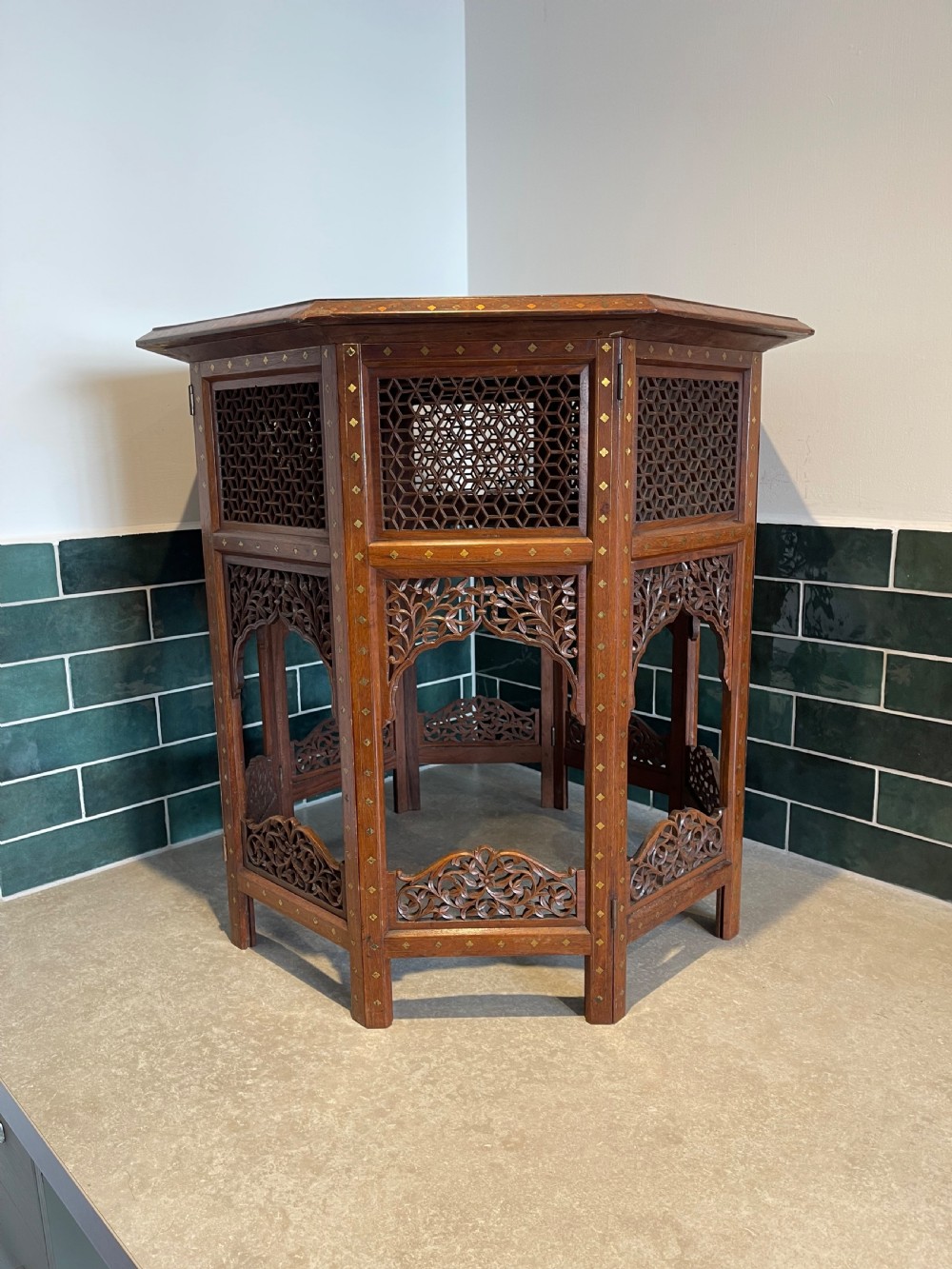 An octagonal Anglo-Indian side table featuring intricate geometric brass inlay on top and carved jali lattice apron panels. View III