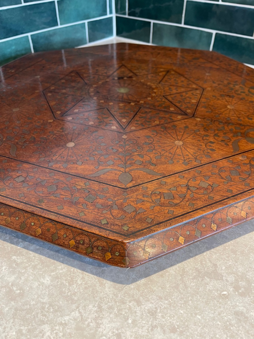 An octagonal Anglo-Indian side table featuring intricate geometric brass inlay on top and carved jali lattice apron panels. View VIII
