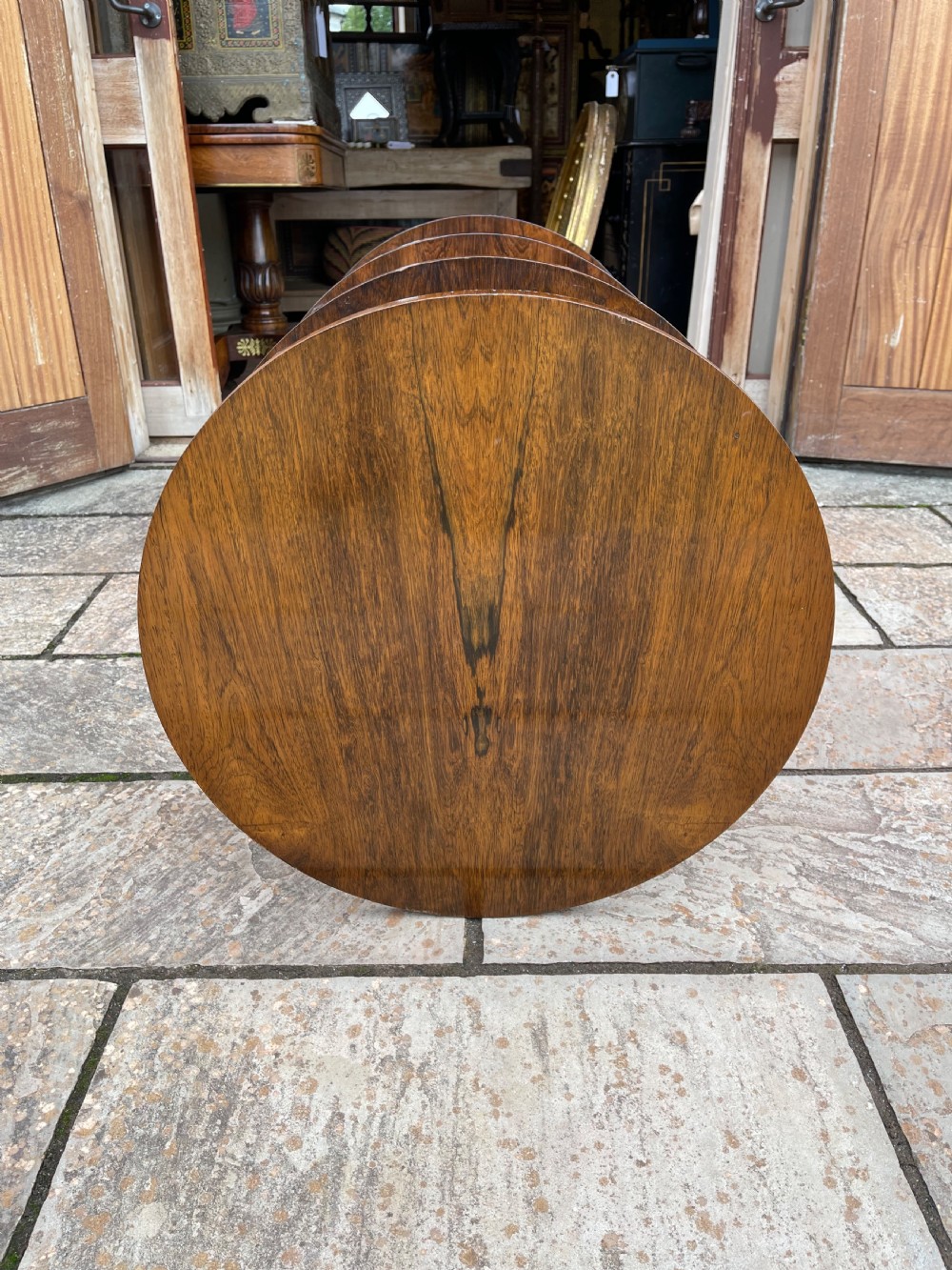 A 19th-century circular rosewood whatnot featuring four open tiers supported by turned columns and set on brass castors. View III