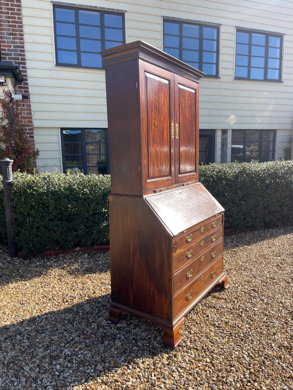 An eighteenth-century mahogany bureau bookcase featuring a two-door upper cabinet, slant-front desk, and four drawers with brass handles. View V