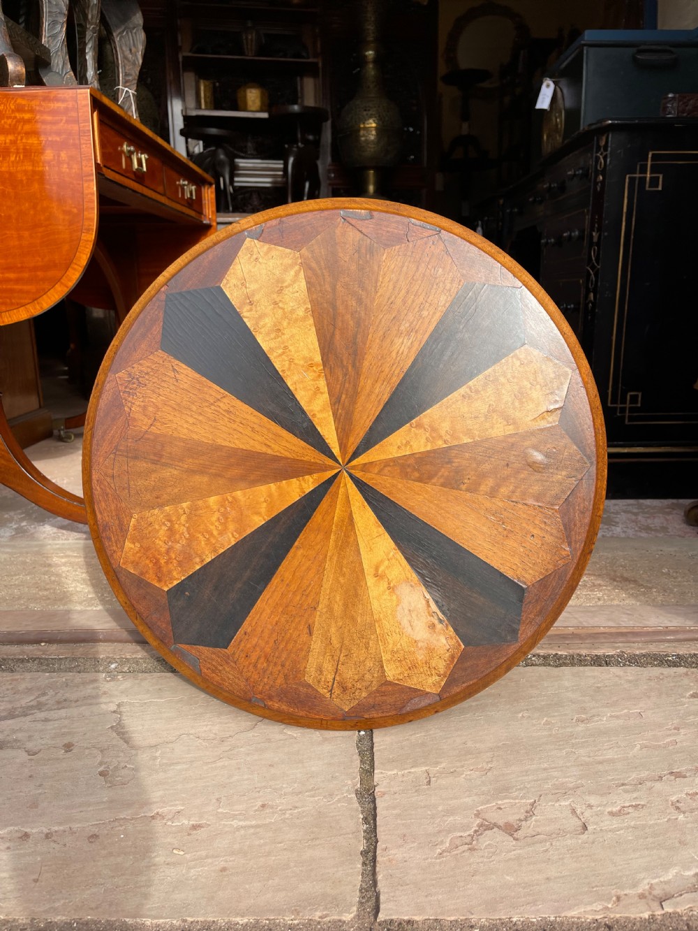 A circular Victorian specimen timber occasional table featuring a starburst parquetry top, a turned central pedestal stem, and three downswept tripod legs. View II
