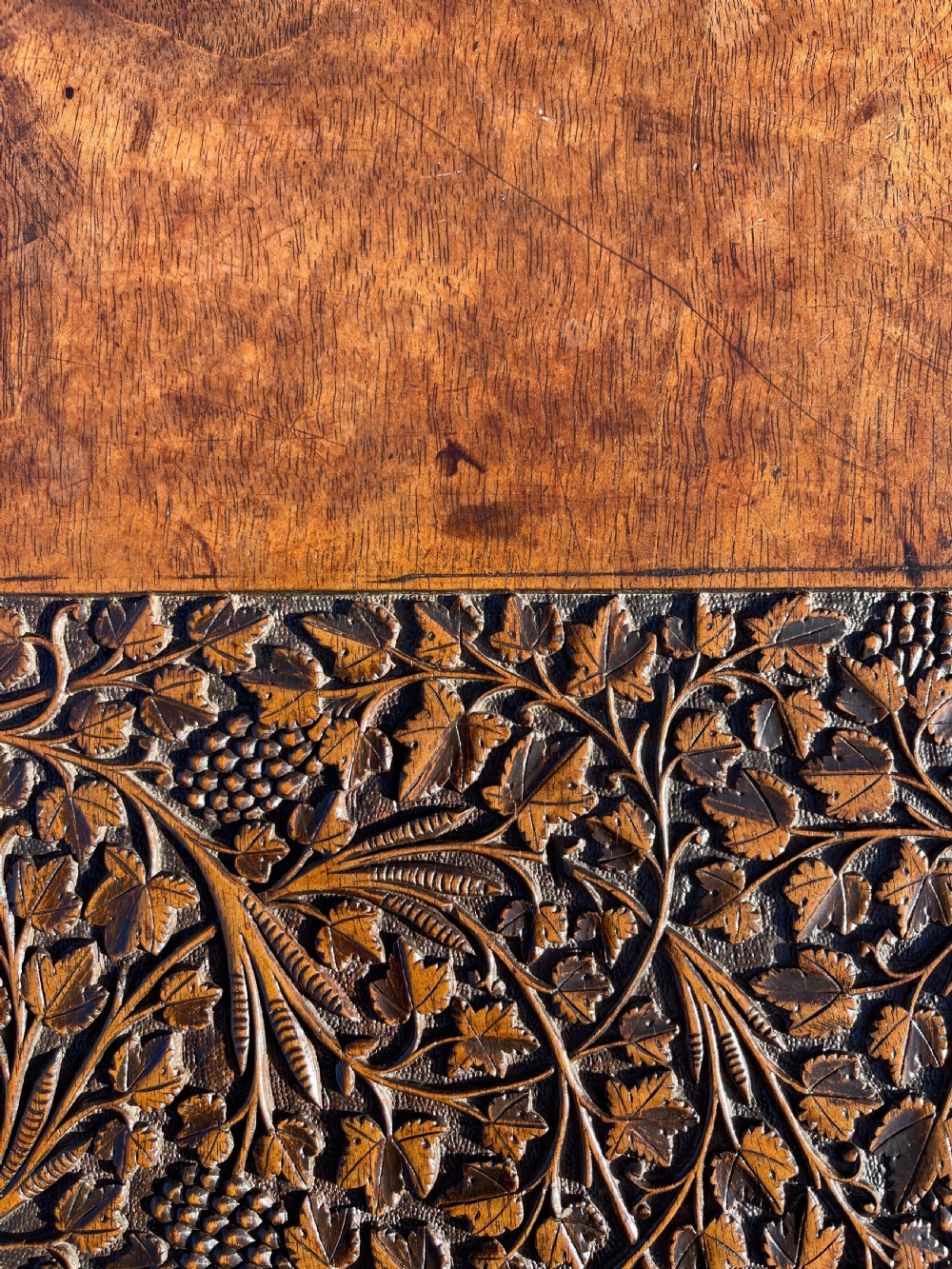 An octagonal dark walnut table featuring detailed botanical relief carving on the tabletop and pierced arched side panels. View IX