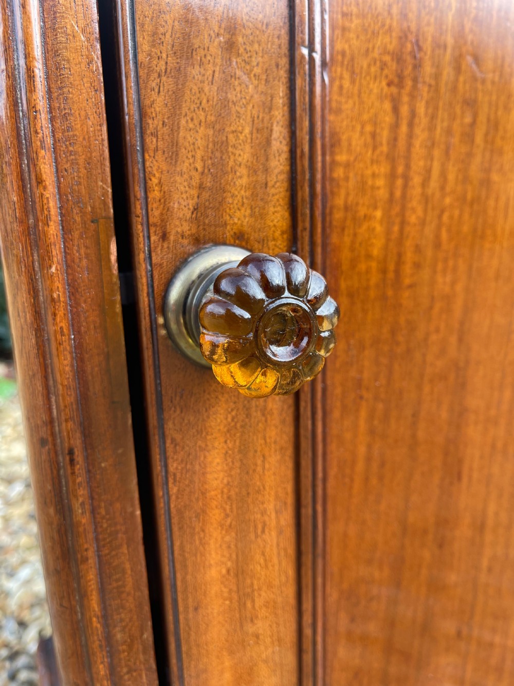 A tall Victorian mahogany pedestal cupboard featuring a low rear gallery upstand, a single panelled door with a turned glass knob, and a solid plinth base. View III