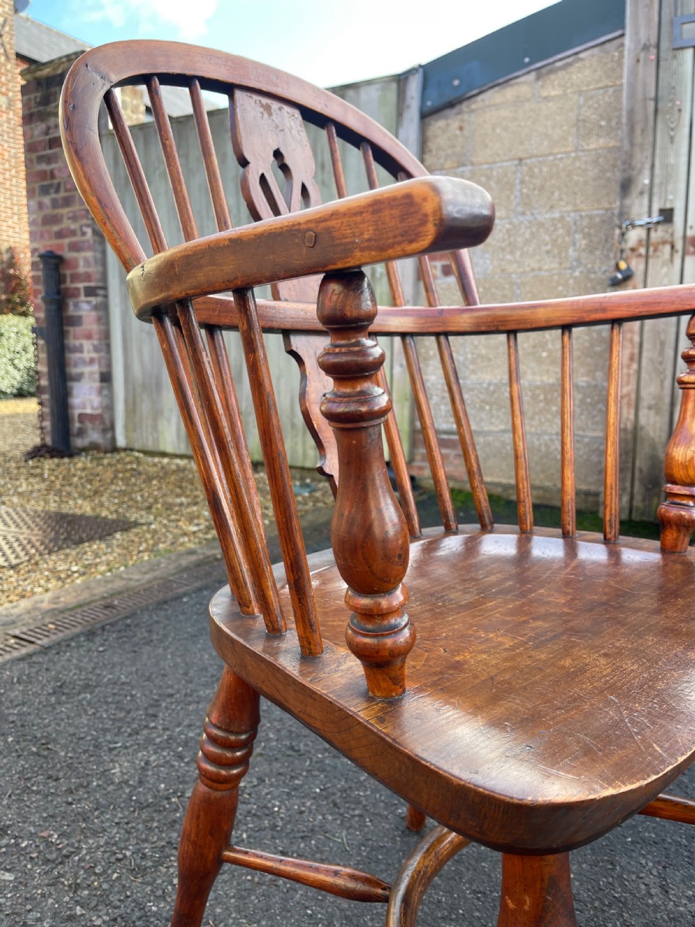 A pair of warm brown wooden Windsor armchairs featuring hoop backs, pierced central splats, turned legs, and curved stretchers. View IV