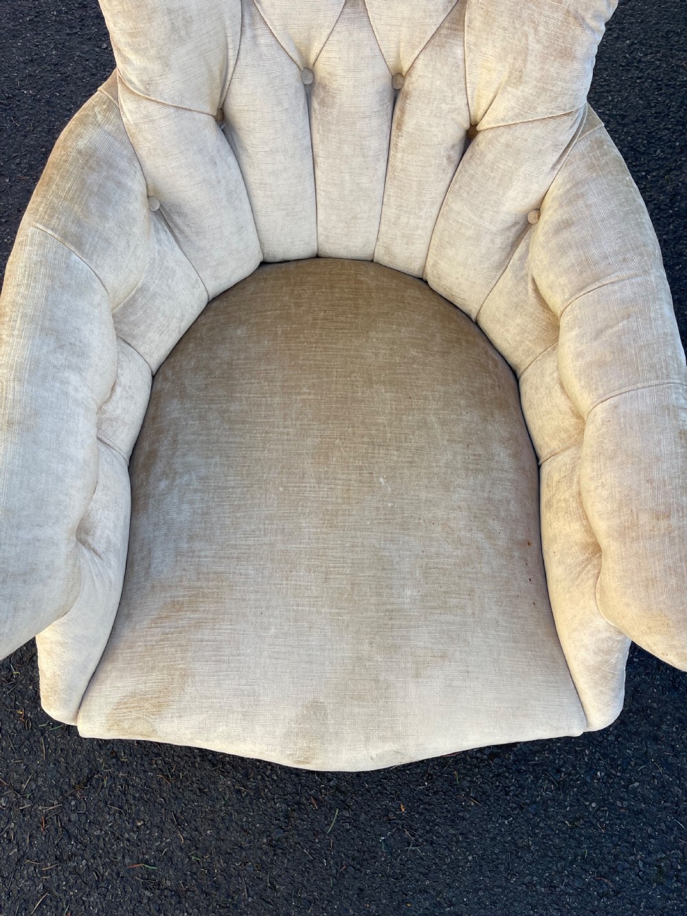 A nineteenth-century Victorian button-back armchair upholstered in beige velvet with scroll arms and turned mahogany legs on white castors. View V