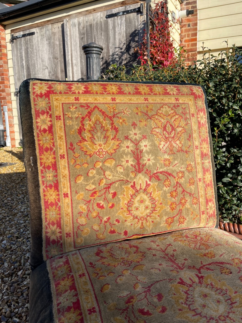 An armless slipper chair upholstered in dark charcoal velvet with a central panel featuring a red and gold oriental carpet pattern. View II