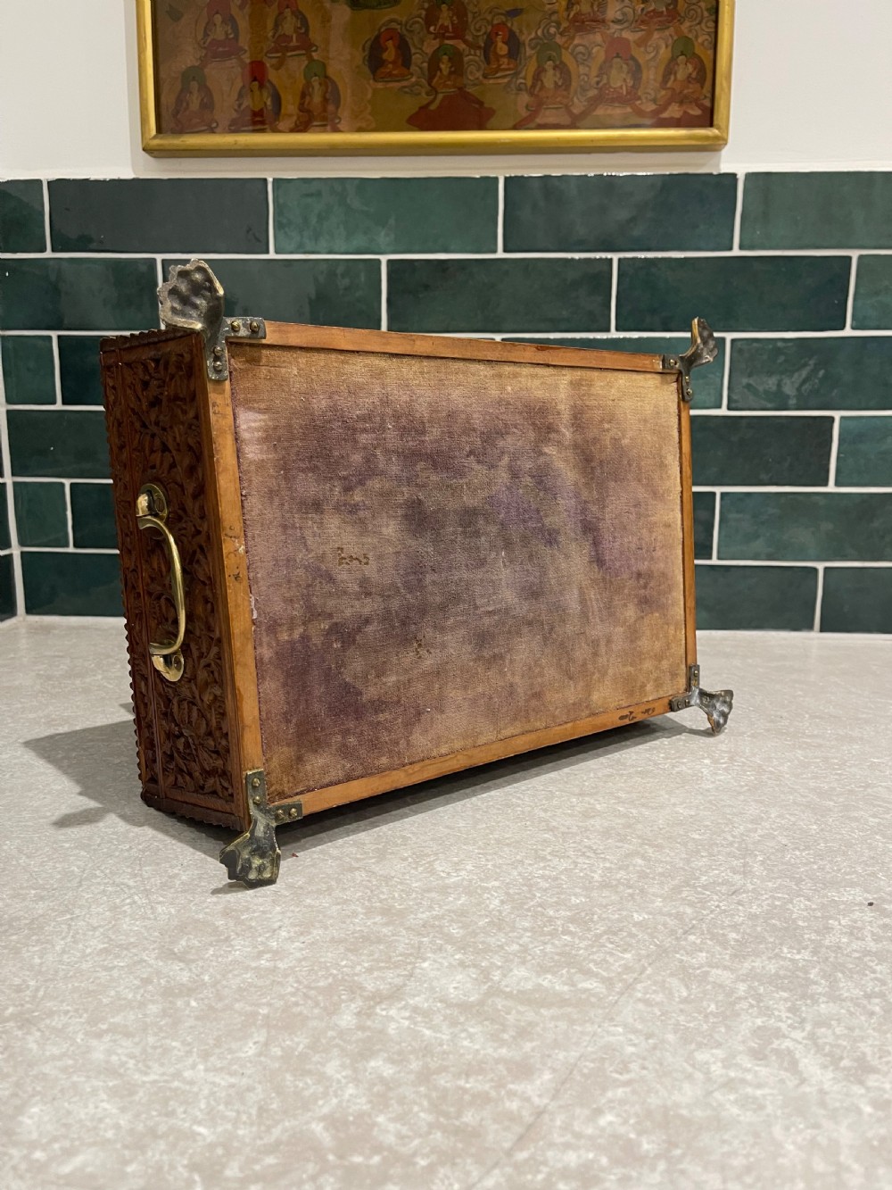 An intricately carved brown sandalwood jewellery box with a stepped lid, brass side drop handles, and brass claw feet. View II