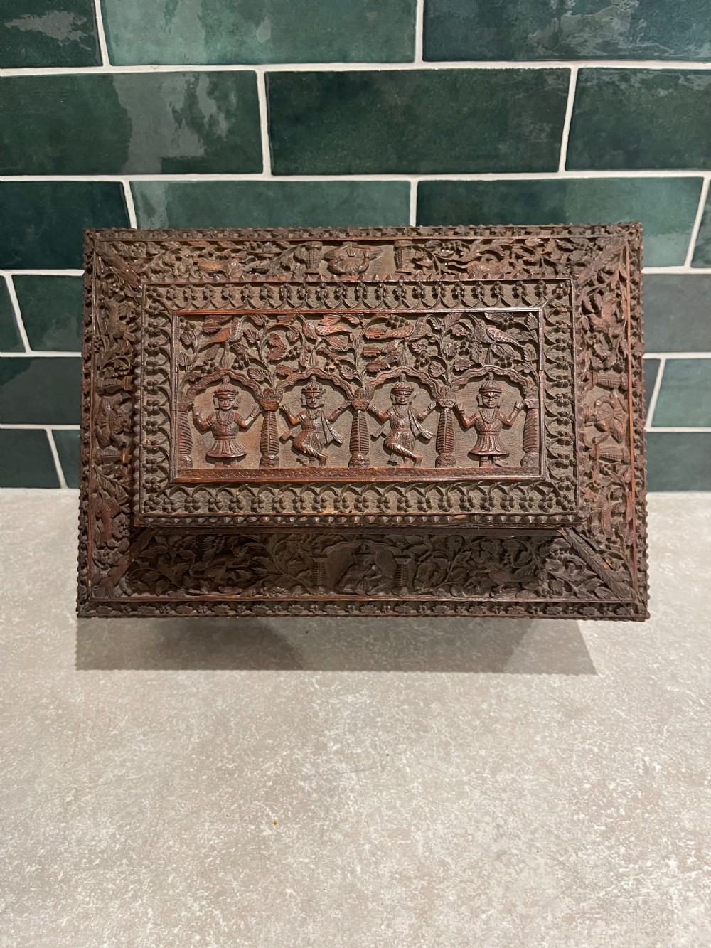 An intricately carved brown sandalwood jewellery box with a stepped lid, brass side drop handles, and brass claw feet. View VIII