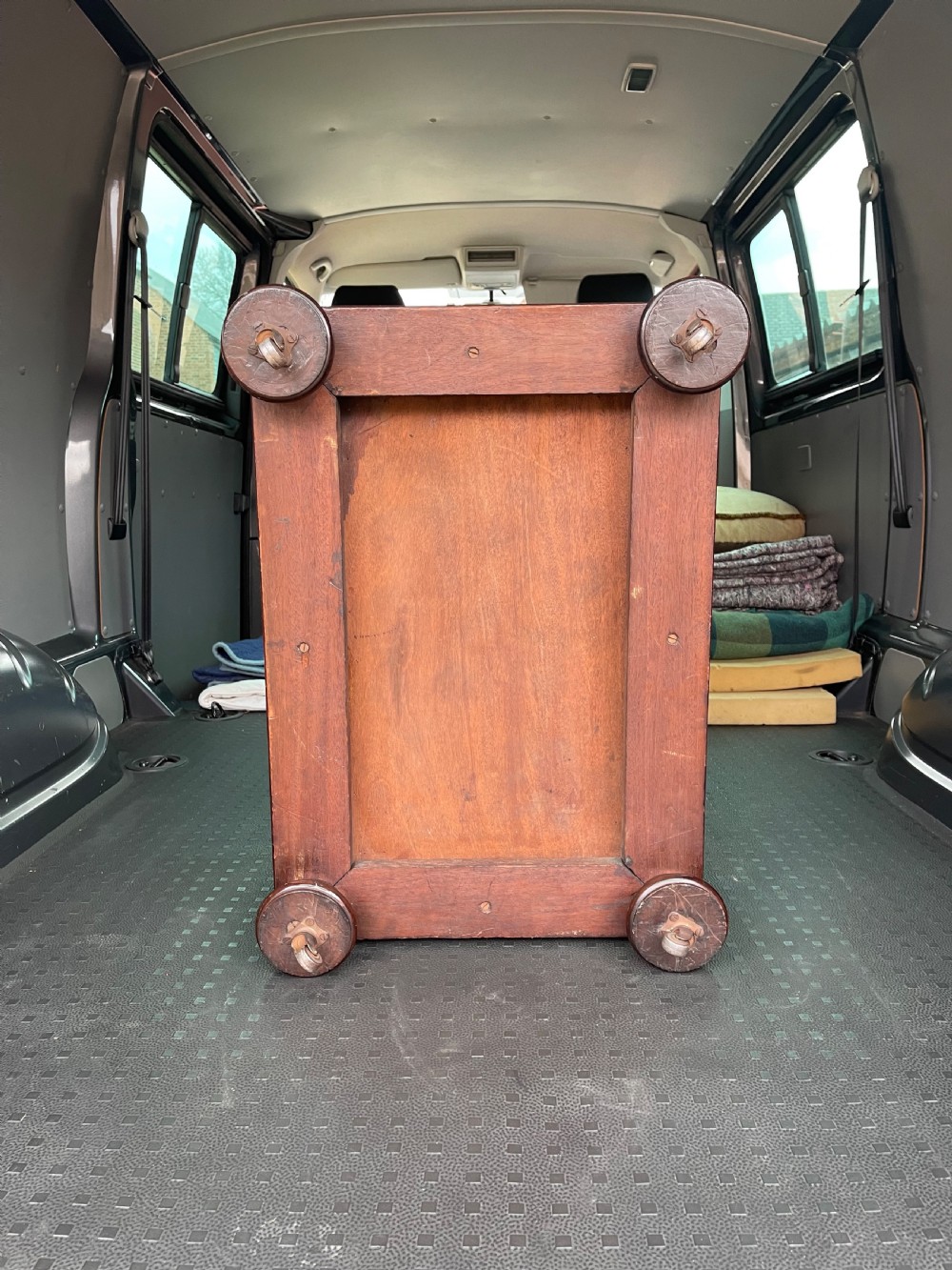 A Regency mahogany cellarette featuring a tapered sarcophagus shape, a hinged lid opening to a hollow interior, ribbed exterior moulding, and turned bun feet. View IV