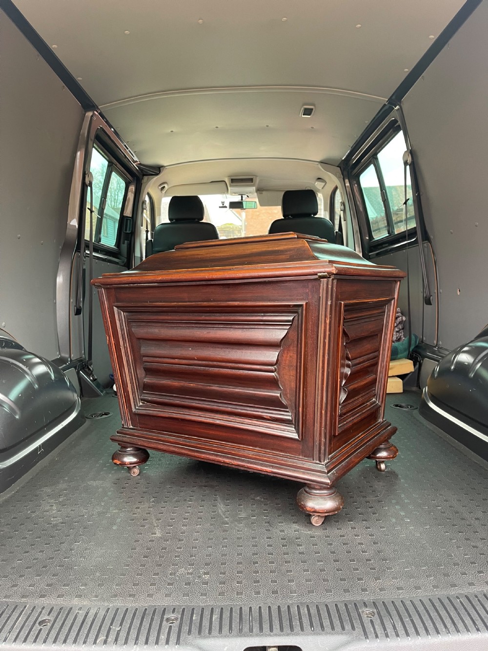 A Regency mahogany cellarette featuring a tapered sarcophagus shape, a hinged lid opening to a hollow interior, ribbed exterior moulding, and turned bun feet. View VII