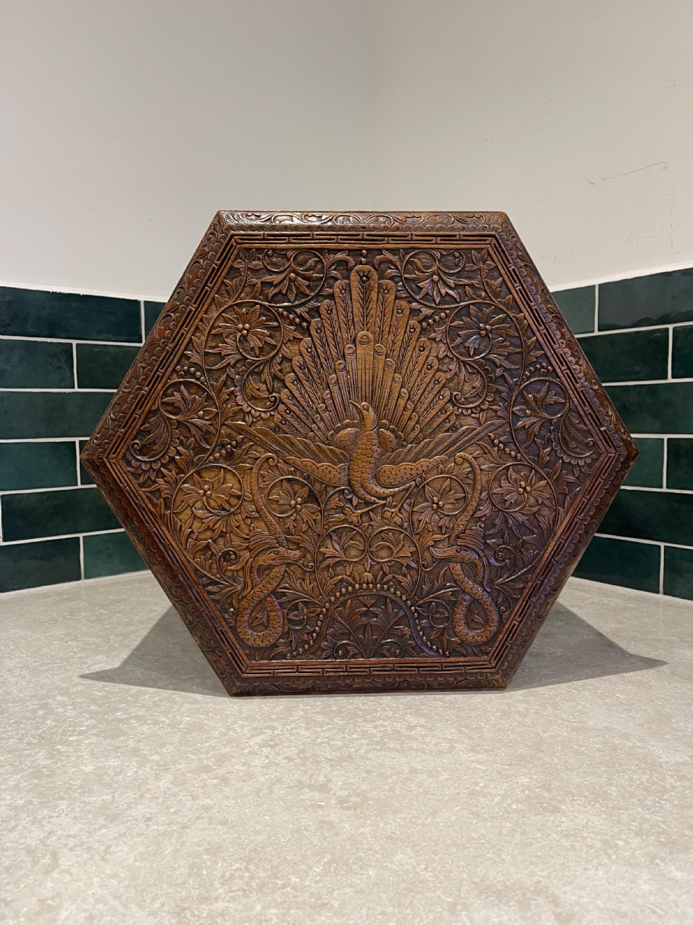 A dark hardwood hexagonal side table featuring intricate hand-carved floral fretwork and pierced side panels with peacock motifs. View II