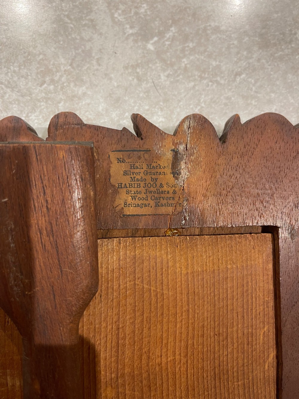 A hand-carved dark walnut picture frame featuring a relief border of chinar leaves and seed pods against a textured stippled background. View II