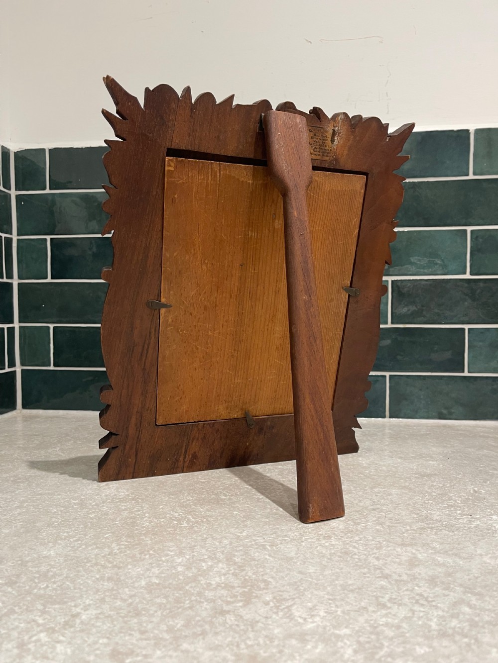 A hand-carved dark walnut picture frame featuring a relief border of chinar leaves and seed pods against a textured stippled background. View III