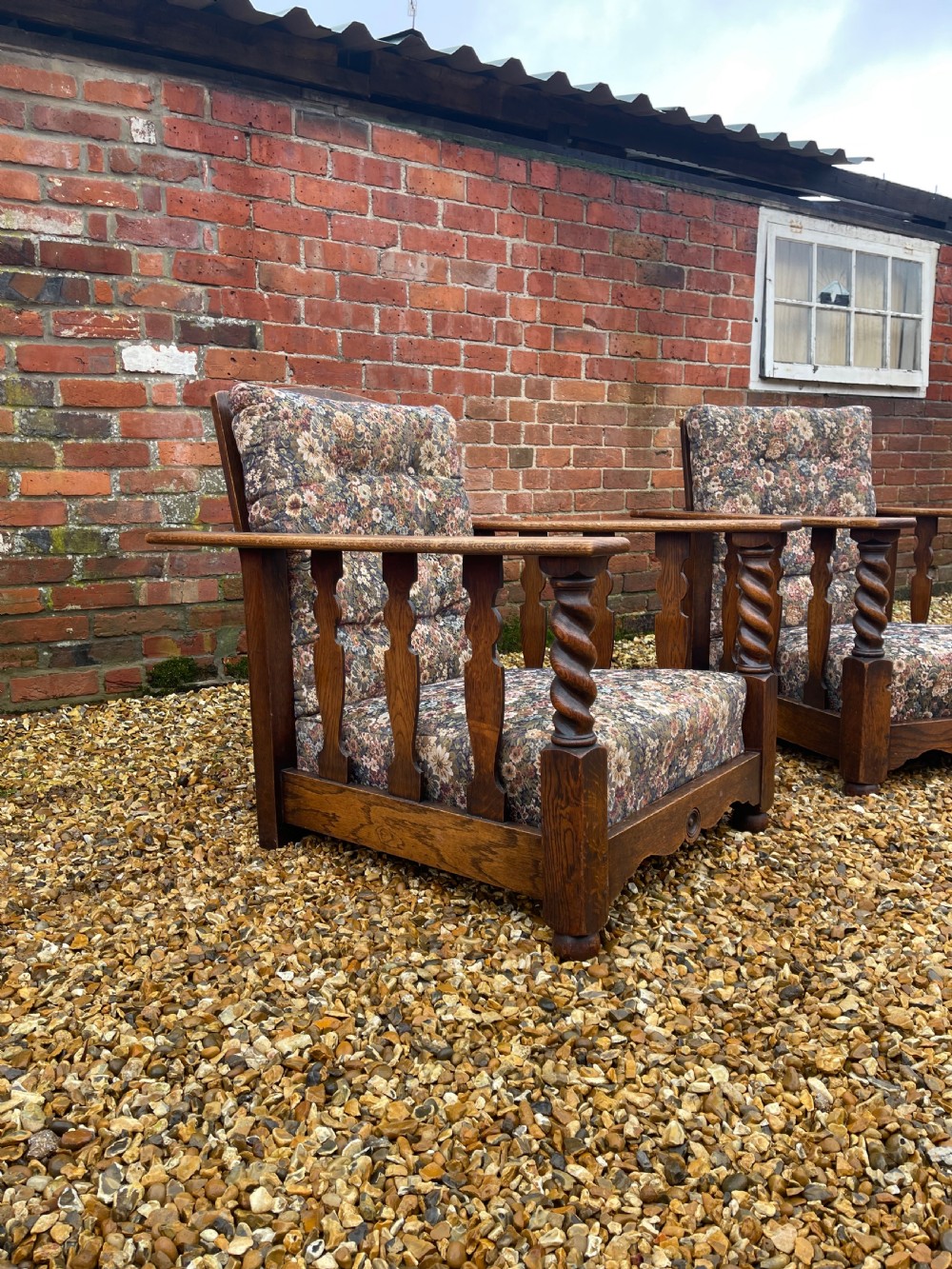 A pair of oak reclining armchairs with floral upholstered cushions, barley twist front arm supports, and slatted side panels. View II