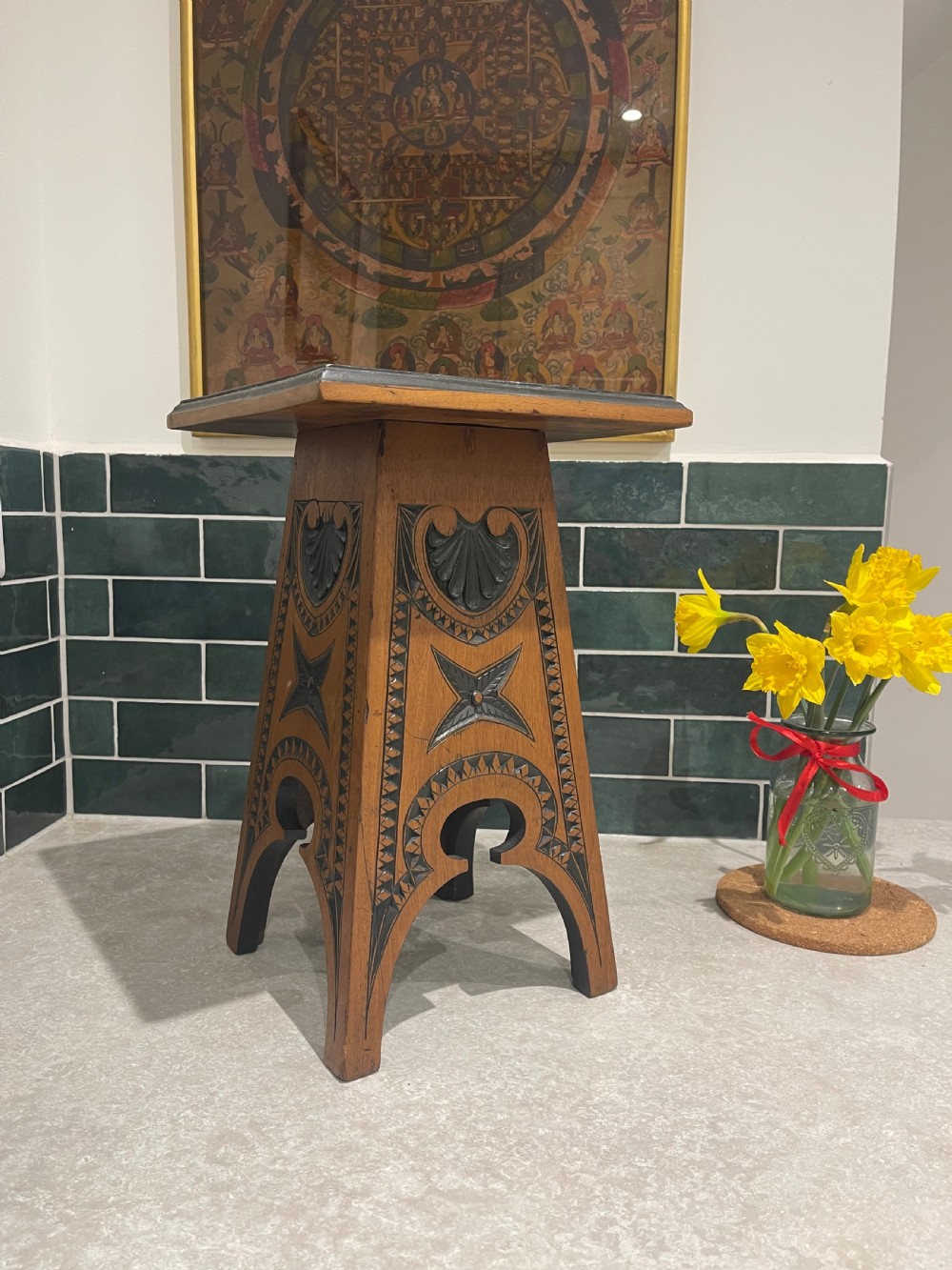 A carved walnut occasional table featuring ebonised geometric chip carving, shell motifs, and four tapered flared legs.
