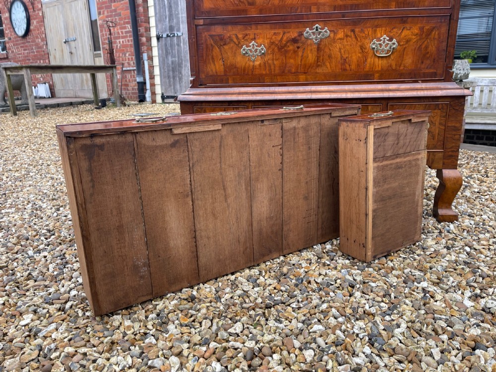 An 18th-century walnut chest on stand featuring crossbanded drawer fronts, brass batwing drop handles, a shaped apron, and cabriole legs. View II