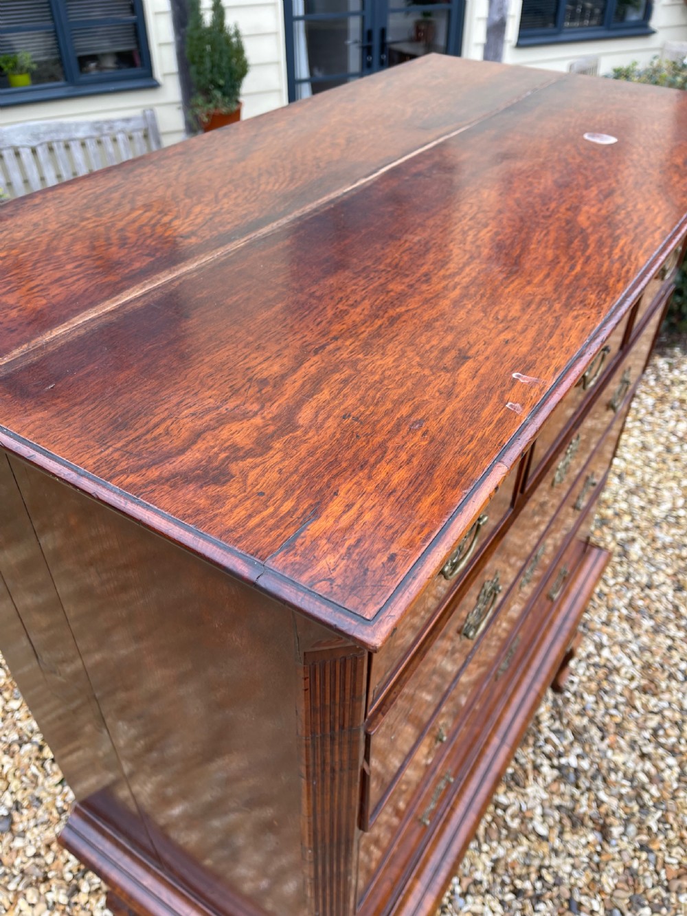 An 18th-century walnut chest on stand featuring crossbanded drawer fronts, brass batwing drop handles, a shaped apron, and cabriole legs. View VI