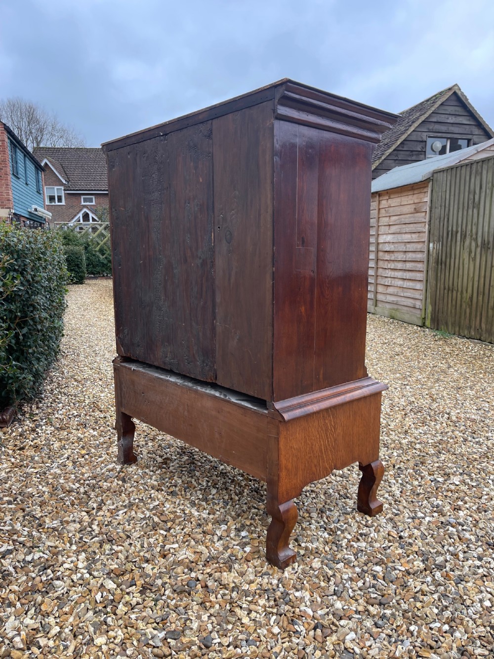 An 18th-century walnut chest on stand featuring crossbanded drawer fronts, brass batwing drop handles, a shaped apron, and cabriole legs. View VII