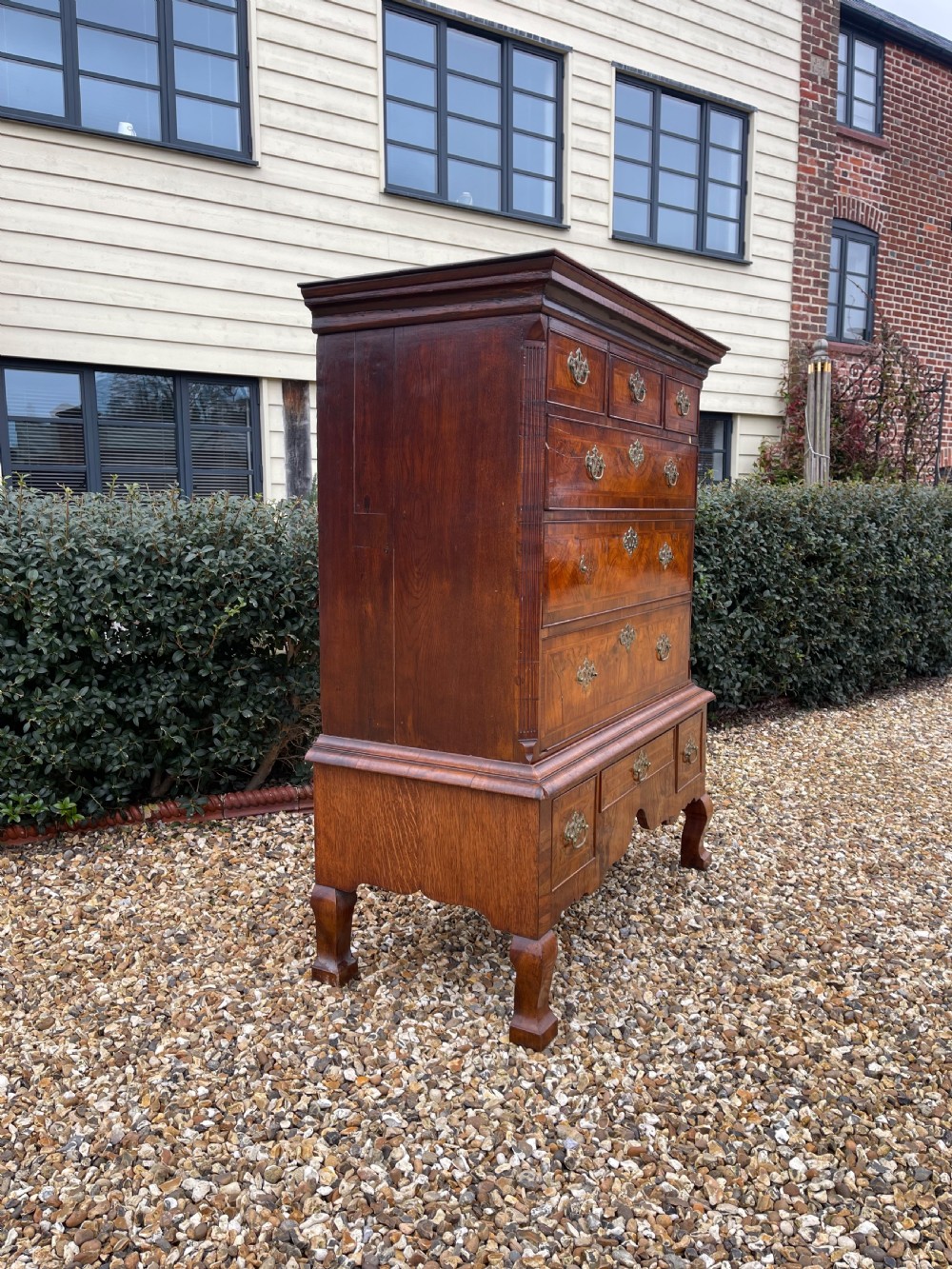 An 18th-century walnut chest on stand featuring crossbanded drawer fronts, brass batwing drop handles, a shaped apron, and cabriole legs. View VIII