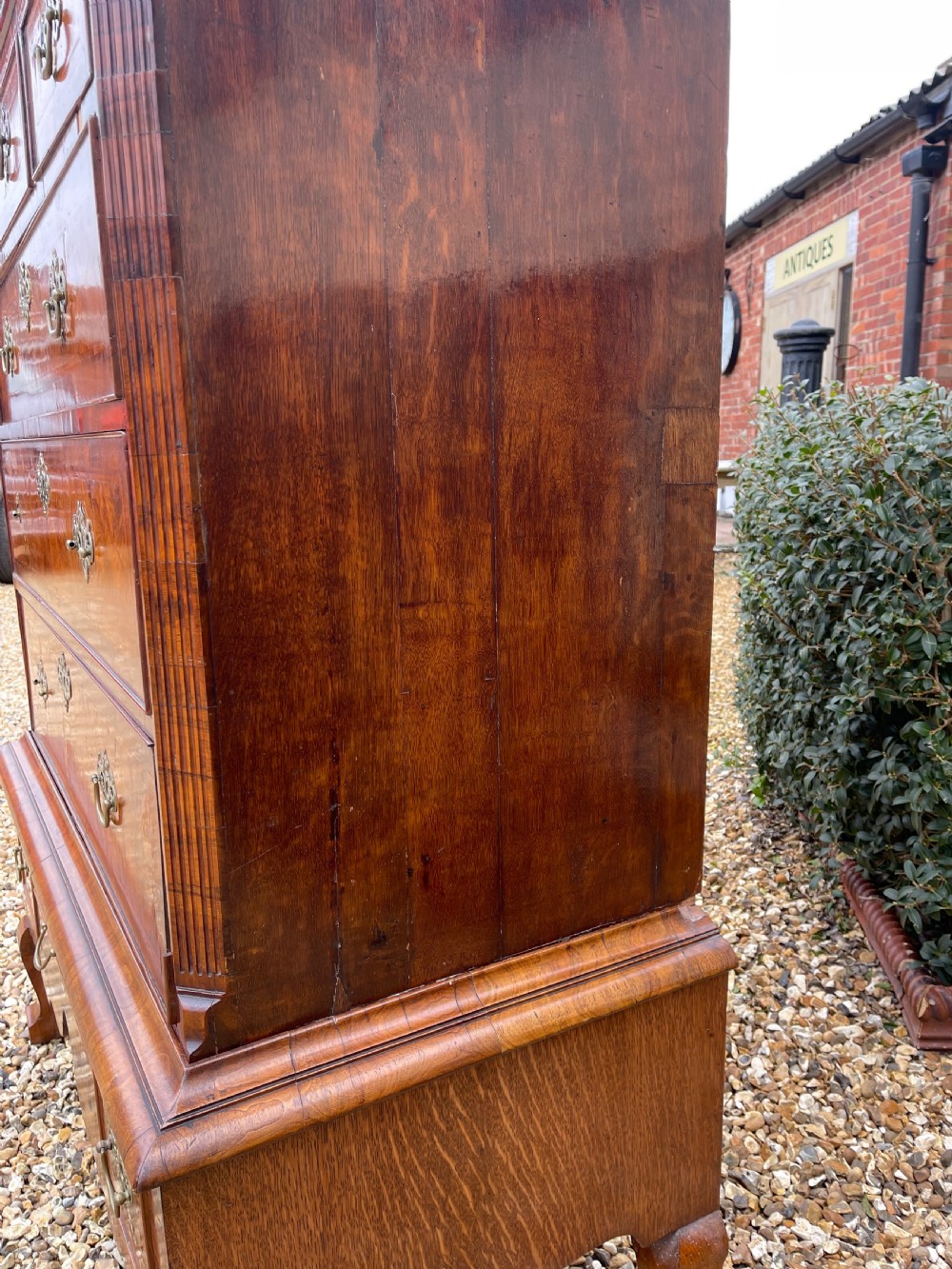 An 18th-century walnut chest on stand featuring crossbanded drawer fronts, brass batwing drop handles, a shaped apron, and cabriole legs. View IX
