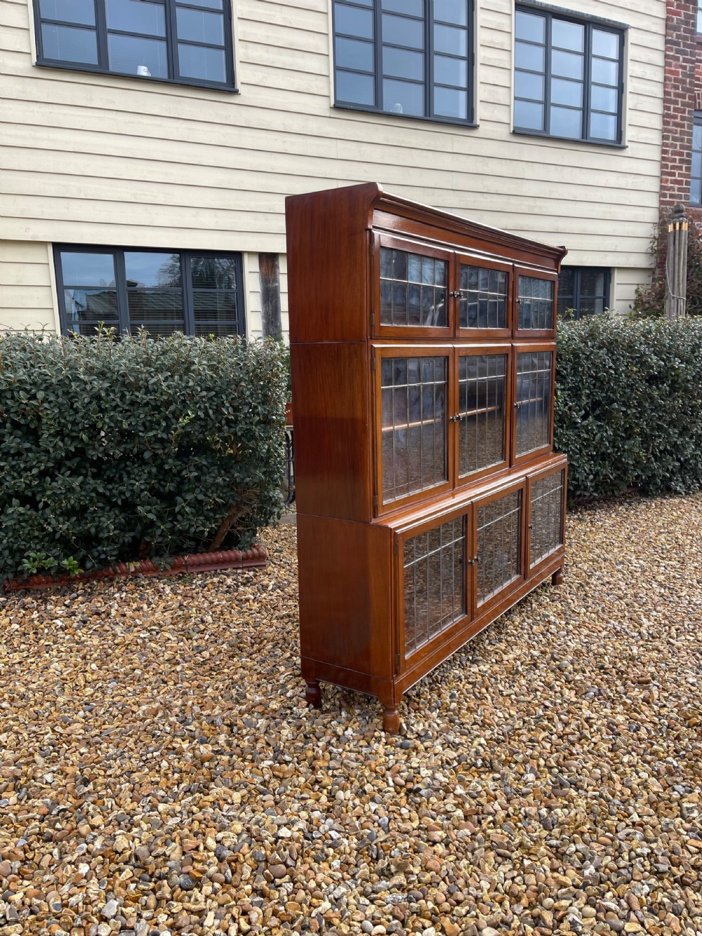 An oak modular stacking bookcase featuring nine leaded glass cabinet doors arranged in three rows. View III