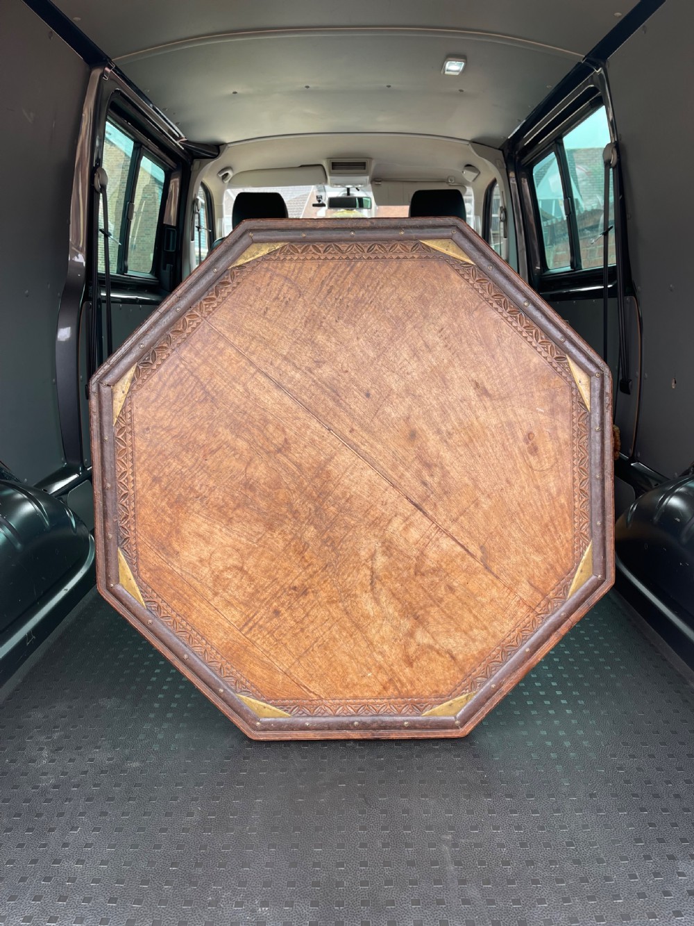 A nineteenth-century octagonal Indian low wooden table featuring intricate carved edges, metal corner reinforcement plates, and four short turned legs. View II