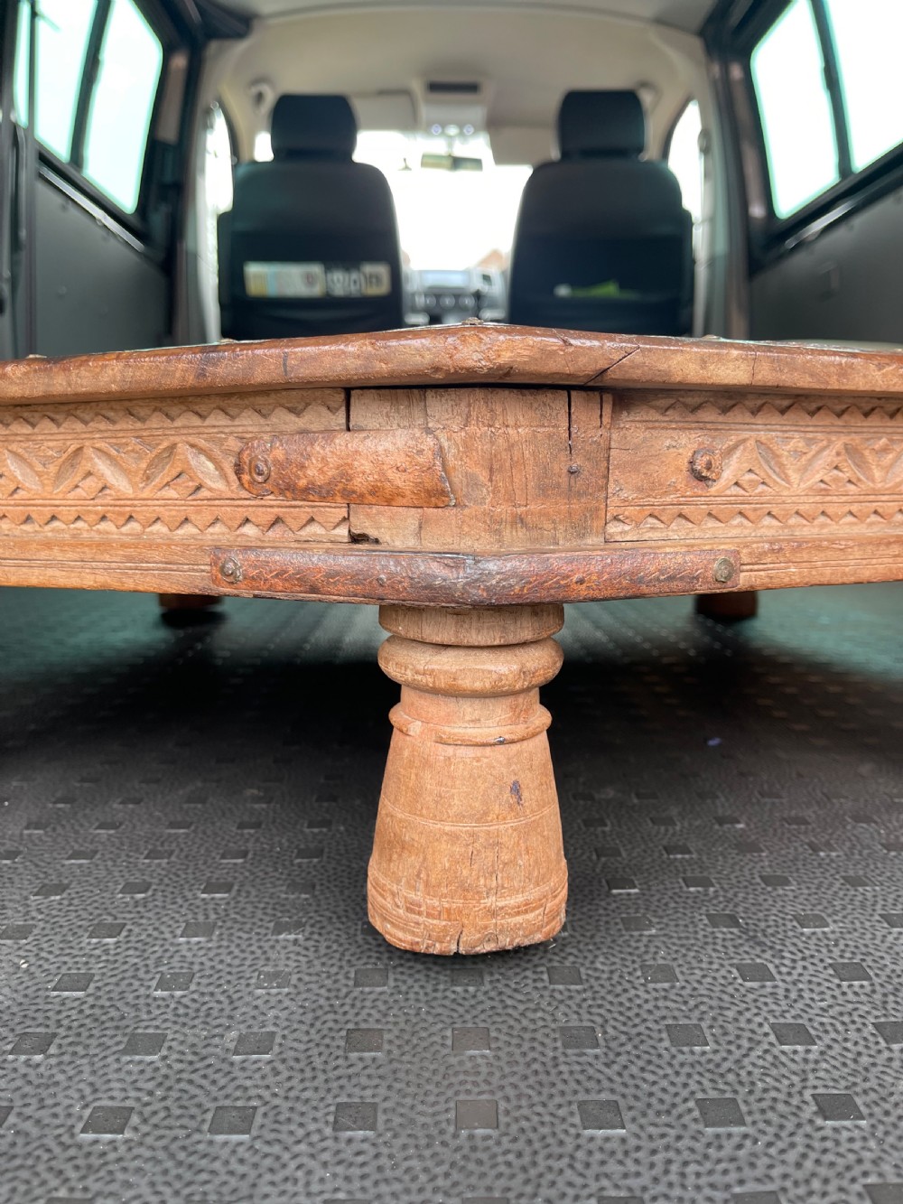 A nineteenth-century octagonal Indian low wooden table featuring intricate carved edges, metal corner reinforcement plates, and four short turned legs. View IV